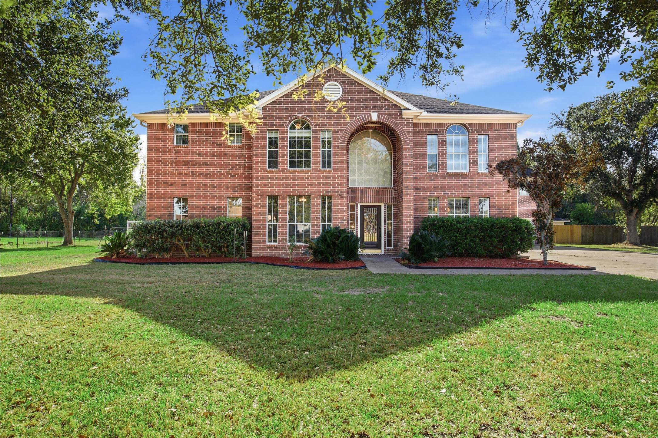 Brick home on a one-acre lot with mature shade trees and a wide front lawn