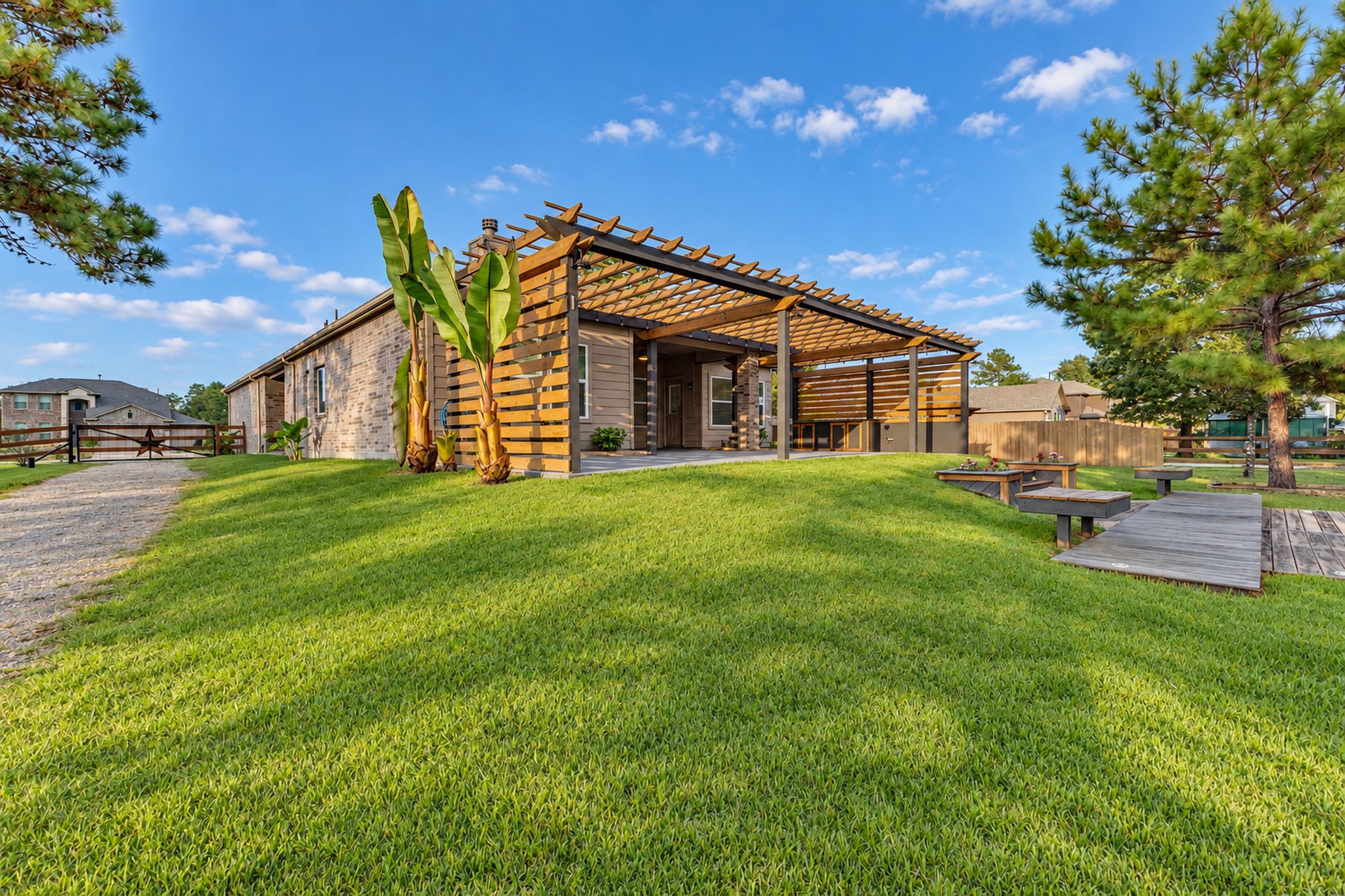 Gated entry to back yard with gravel driveway