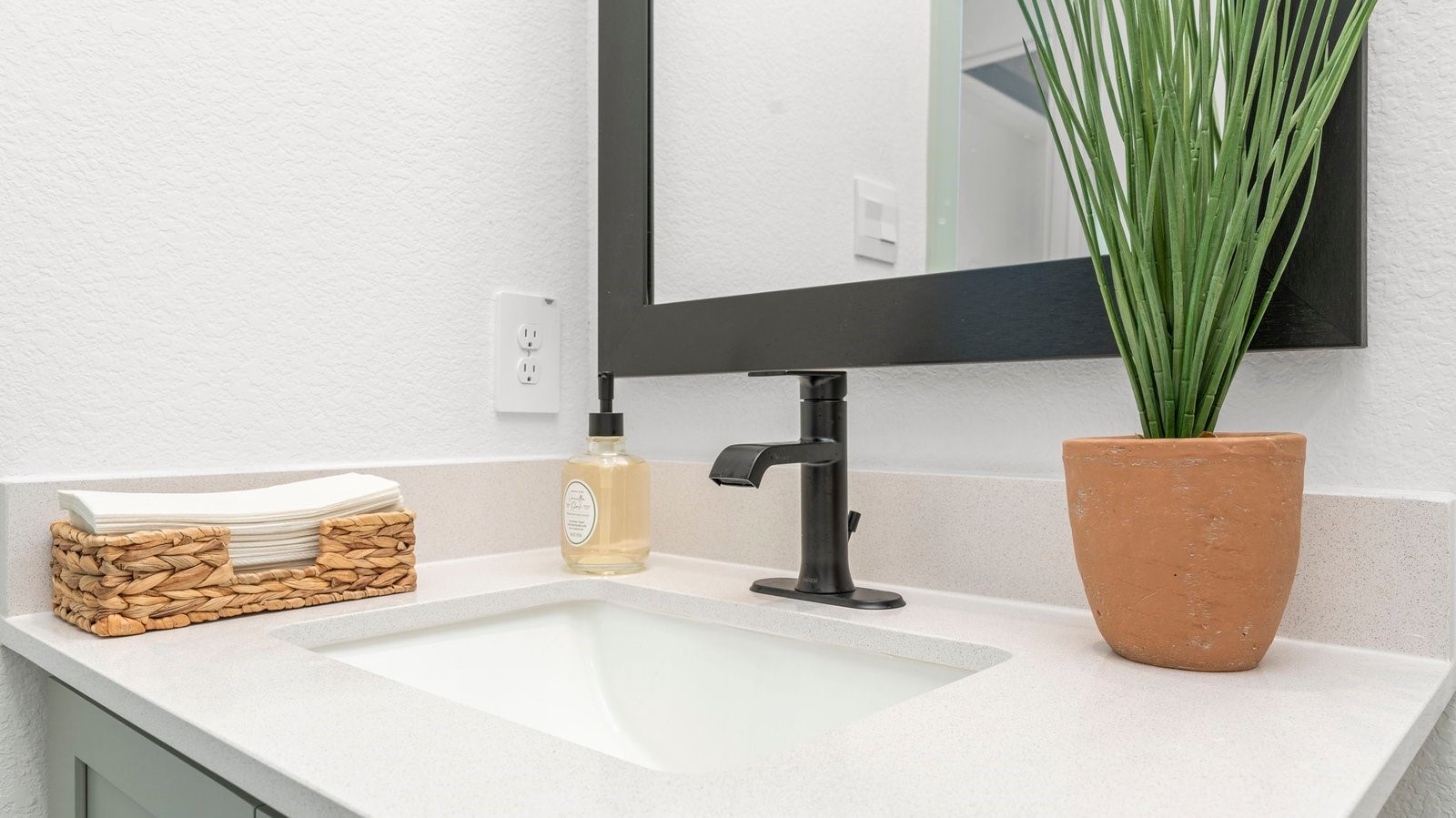 A well-designed bathroom equipped with quartz countertops, a standing tub, and a single vanity.
