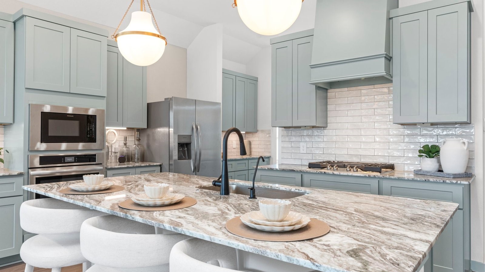 An open concept kitchen with an island with bar seating and access to the living and dining areas.