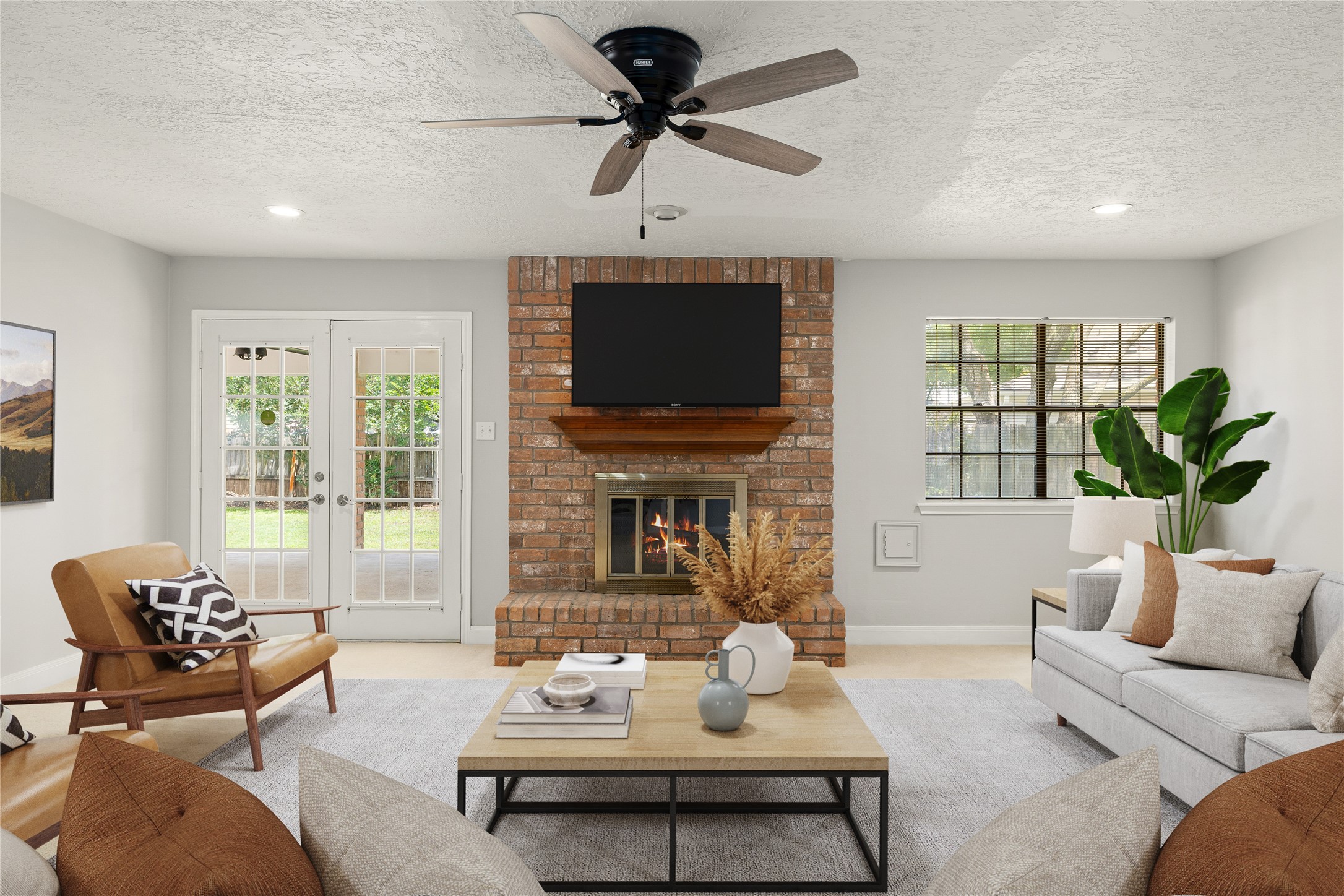 The focal point of this light-filled family room is a handsome floor-to-ceiling brick fireplace with a custom wood mantel, creating an inviting space for relaxation or entertaining. *Virtually Staged