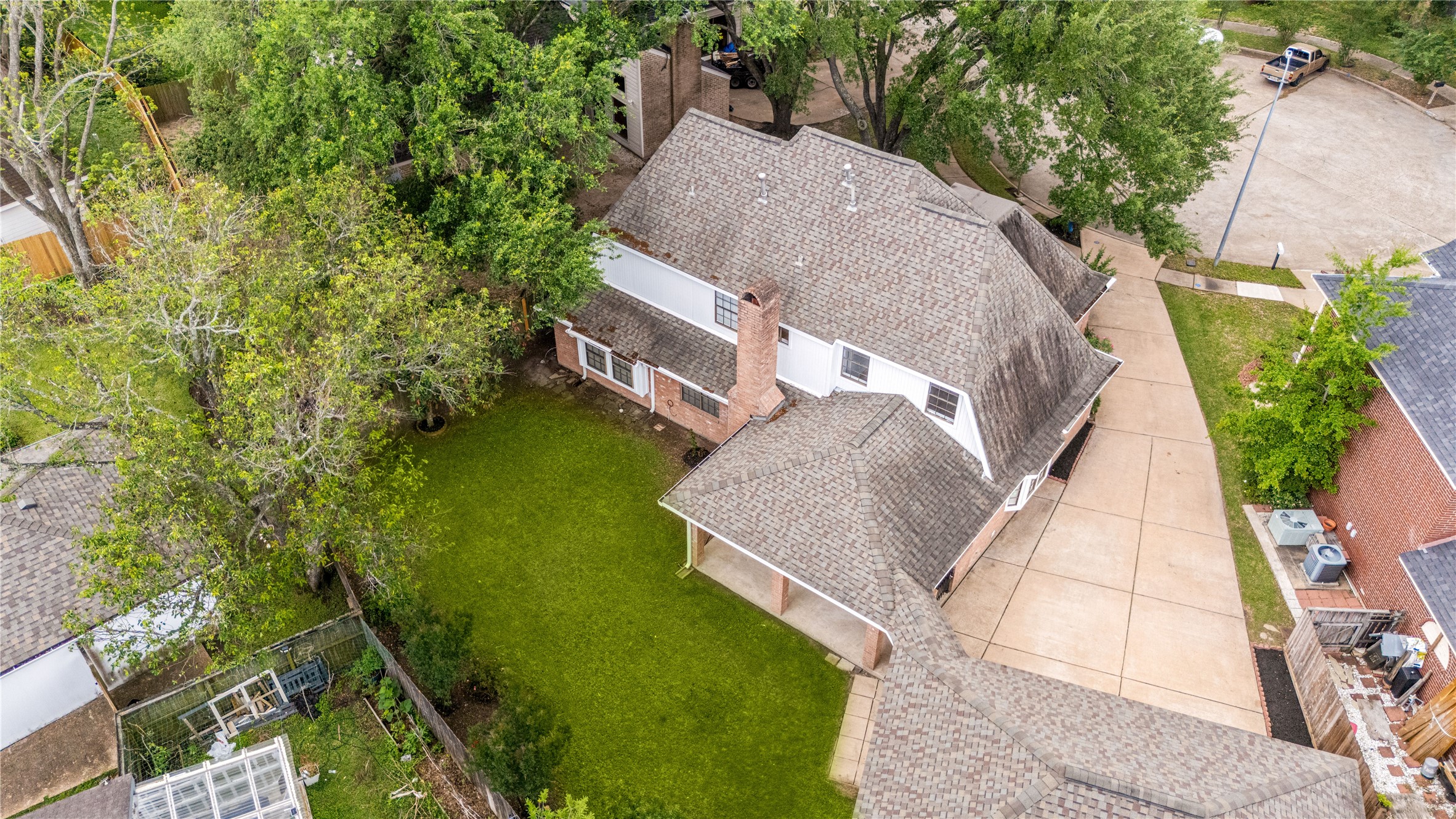Drone view of the backyard and long driveway to detached 3-car garage.