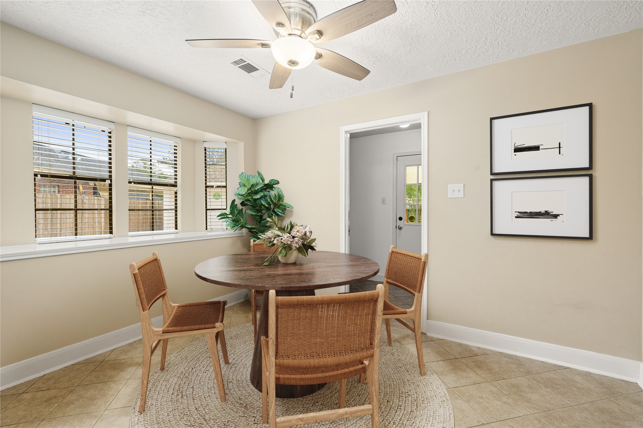 Start your mornings in this sun-drenched breakfast nook, where a charming bay window offers peaceful views of the outdoors. This intimate dining space is perfectly positioned for casual meals and morning coffee, blending comfort with a bright, airy aesthetic. *Virtually Staged