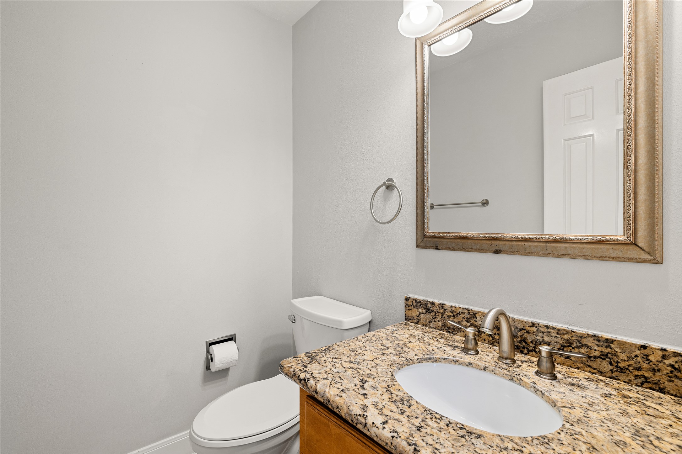 Tucked away for privacy but conveniently located near the main living areas, this thoughtfully updated powder room features granite countertop vanity, framed mirror and sleek modern finishes.