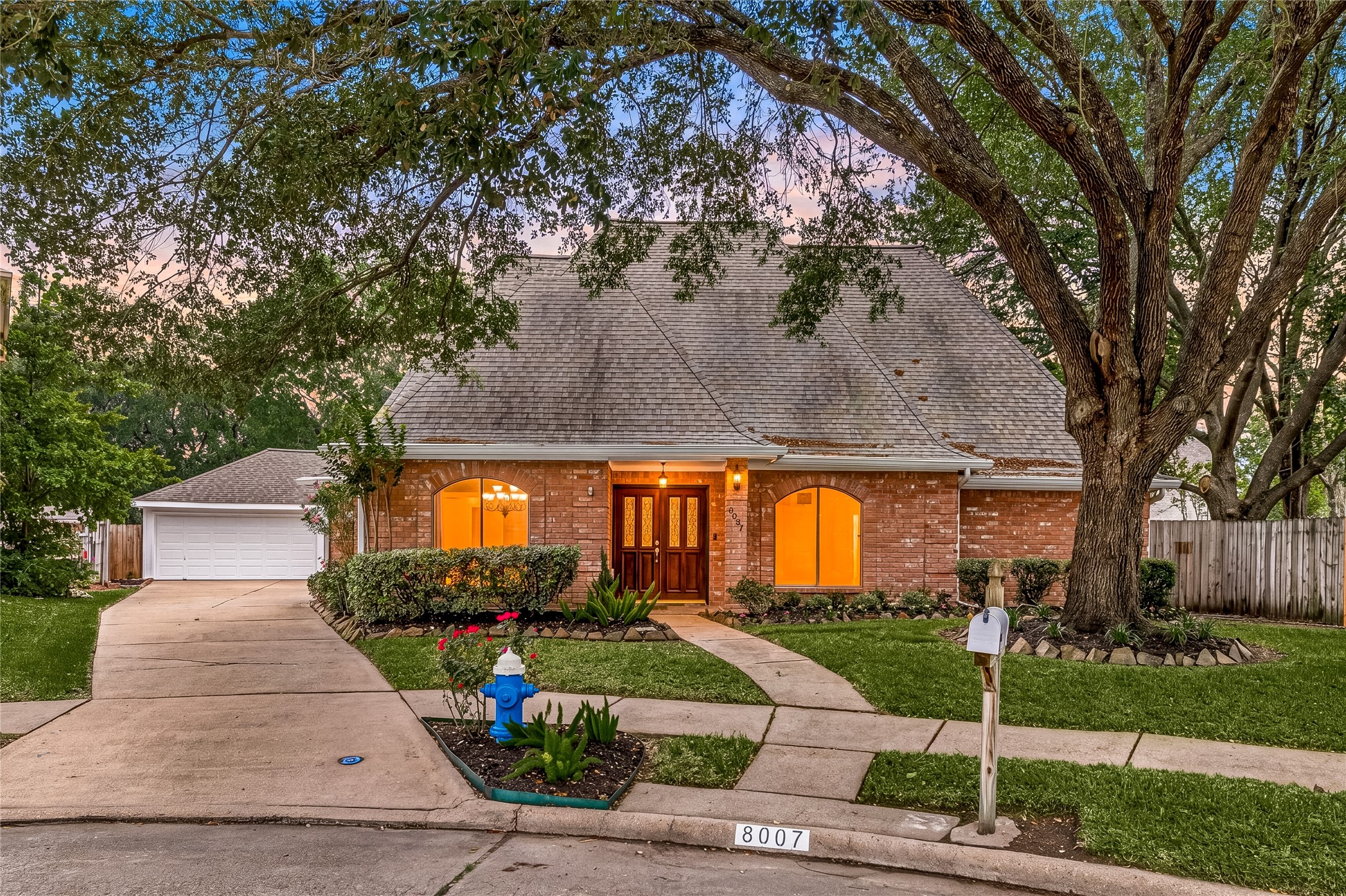 Welcome to 8007 Suspiro Drive, located in Mission Bend San Miguel and zoned to Fort Bend ISD. This home showcases a beautiful curb appeal with a manicured lawn and a majestic, mature oak tree. The charming brick. arched windows, and double front doors offers an inviting first impression.