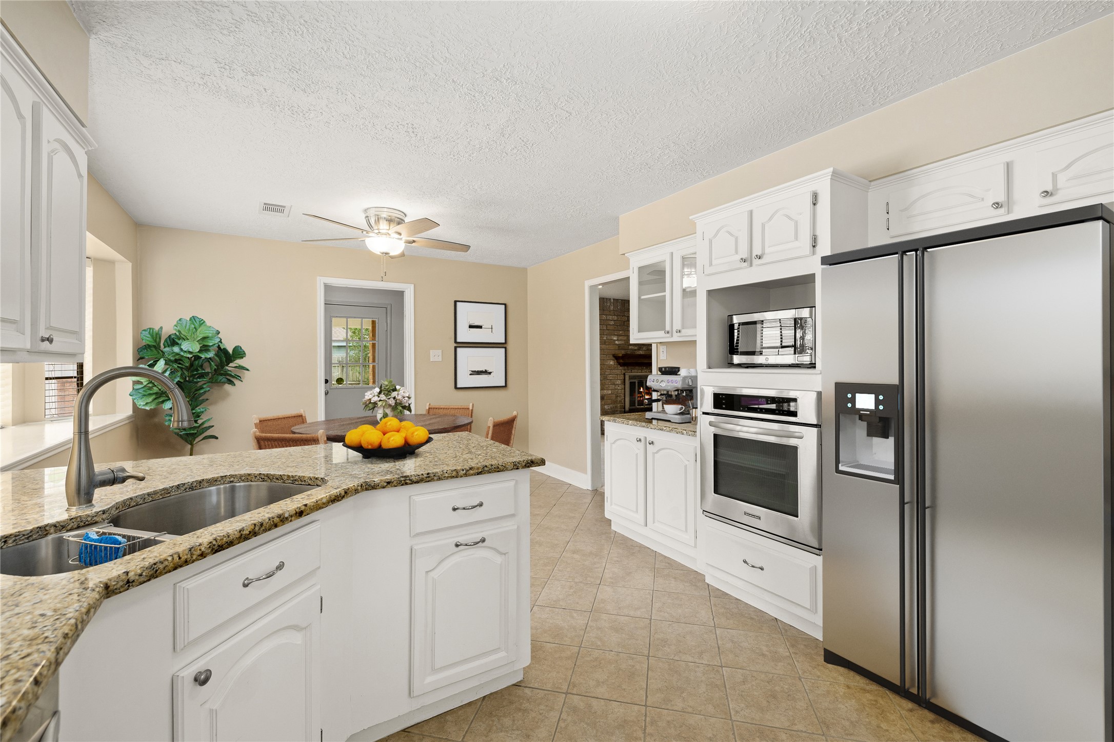 This expanded view showcases a highly functional gourmet layout, featuring a dedicated wall of appliances and a convenient coffee station. The kitchen's open design ensures the chef is always part of the conversation, with clear sightlines into both the breakfast nook and the main living areas. *Virtually Staged