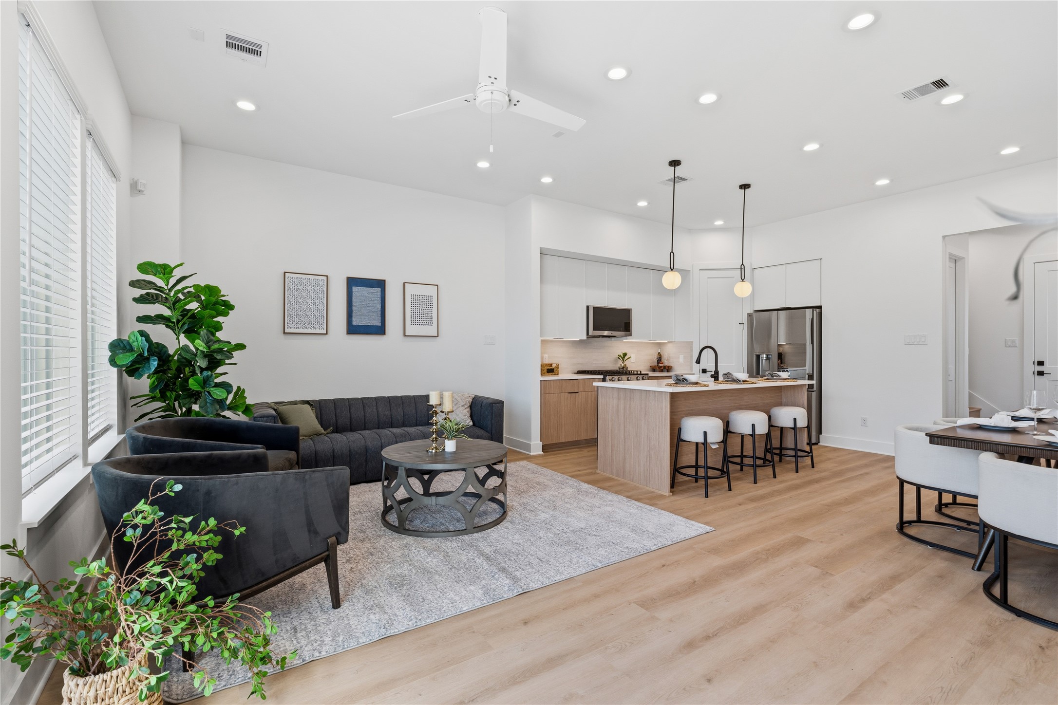 Open-concept living and kitchen area with 10 ceilings, expansive windows, and seamless flow, ideal for entertaining.
