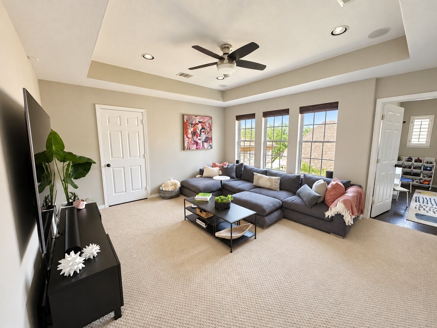 This comfortable upstairs game/media room provides generous seating, privacy, ample natural light and convenient access to the adjoining room (currently used as a playroom).