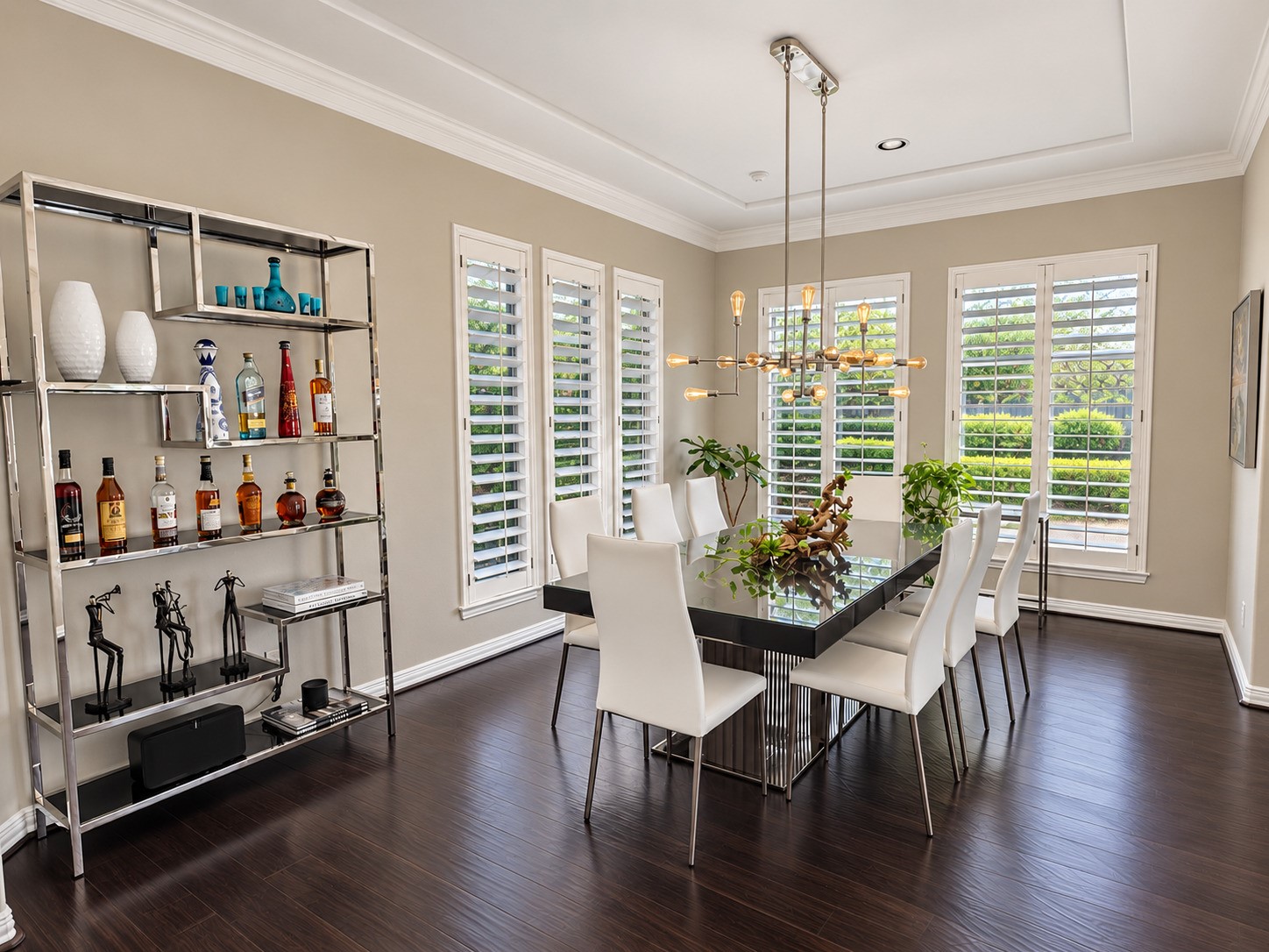 The formal dining room combines a modern chandelier, plantation shutters and generous space for gatherings.