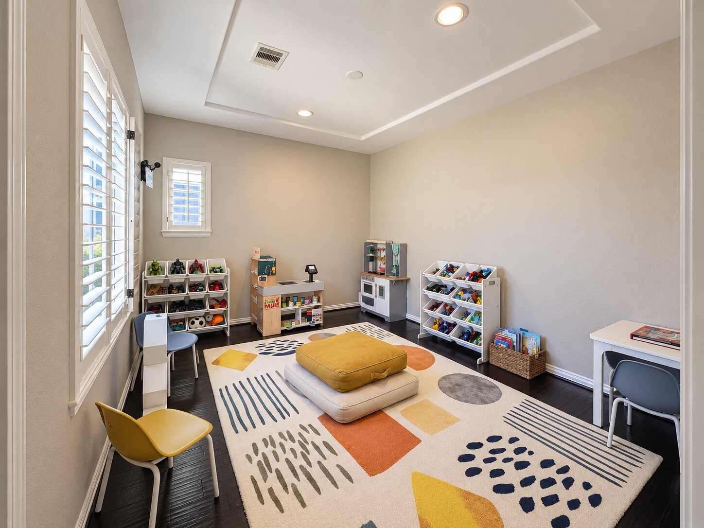 Another bedroom currently arranged as a bright playroom with dedicated areas for imaginative play, reading, and storage. This versatile space can easily adapt to suit a variety of needs.