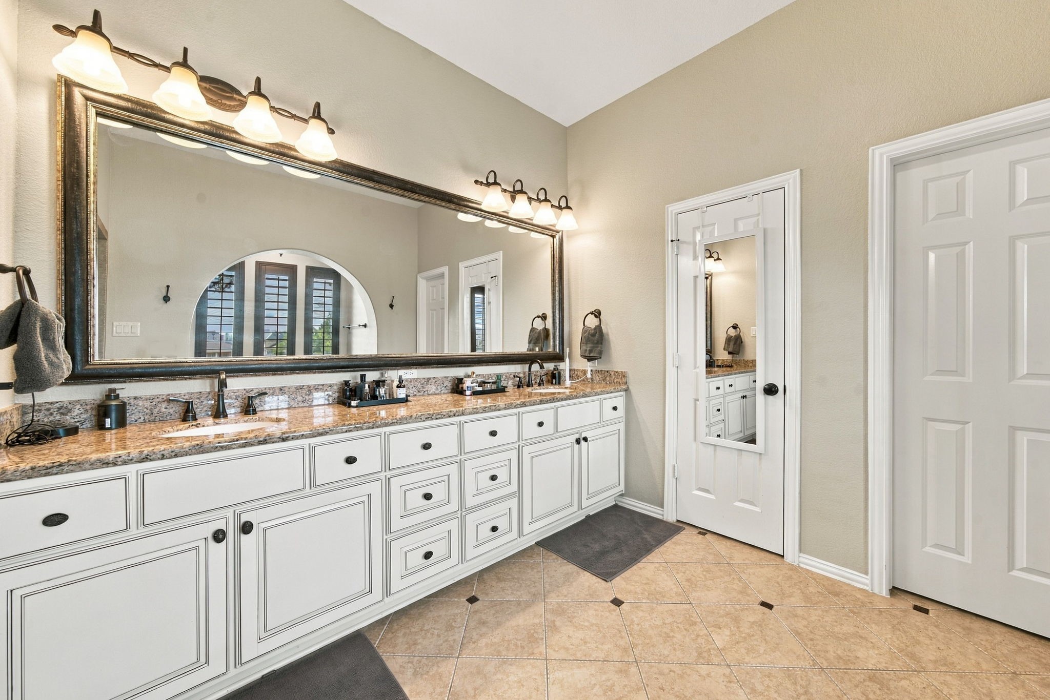 An extended dual-sink vanity provides abundant counter space in the primary bathroom and extensive cabinetry.
