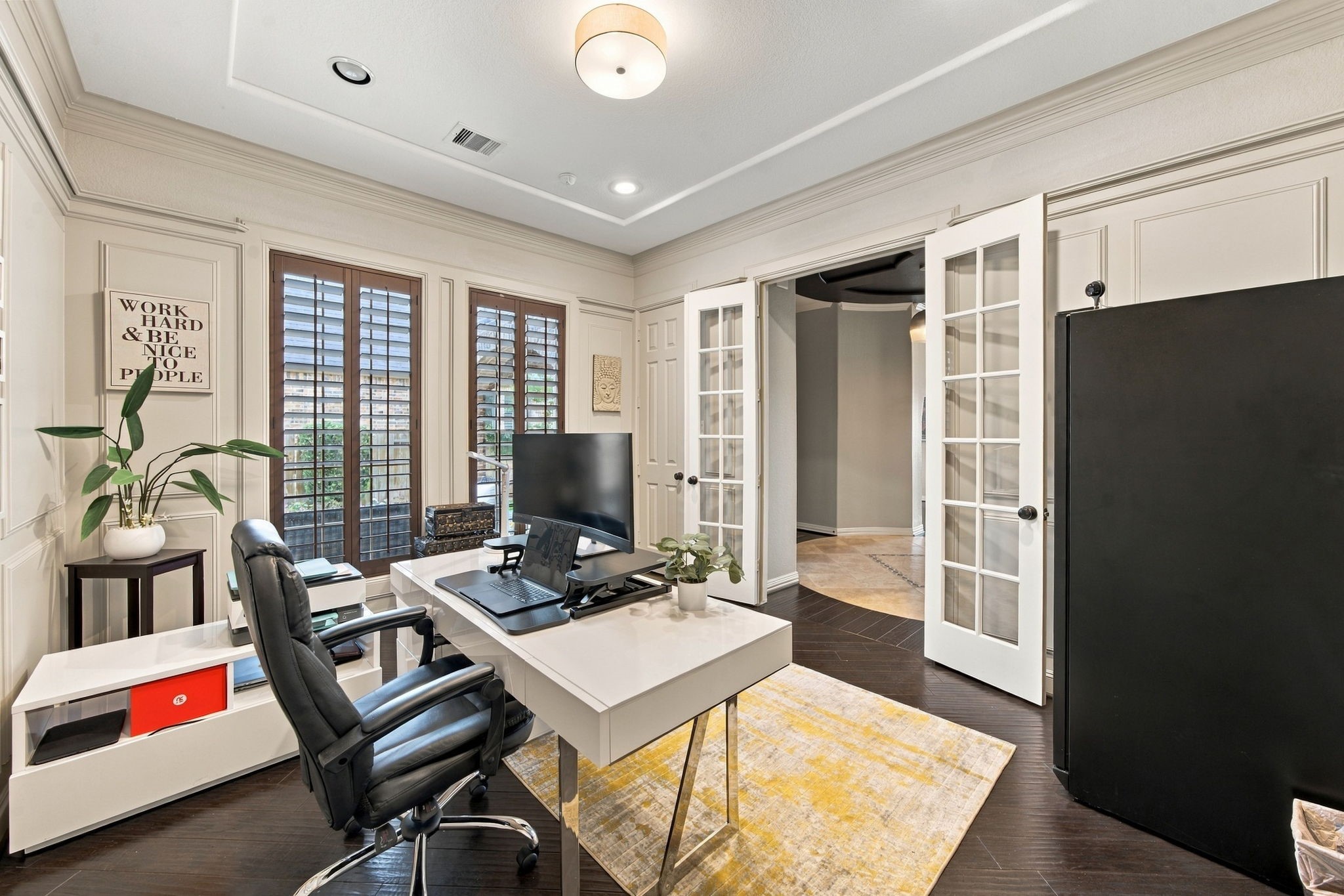 The private home office features elegant wall paneling, plantation shutters, hardwood floors and French doors opening to the main foyer.