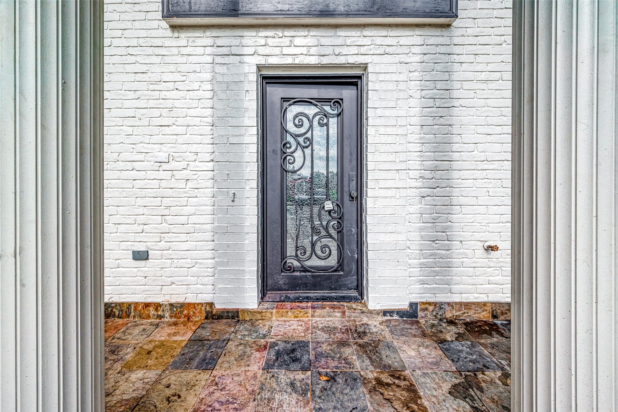 Elegant entrance with a black wrought iron door. Elegant entrance with a black wrought iron door.