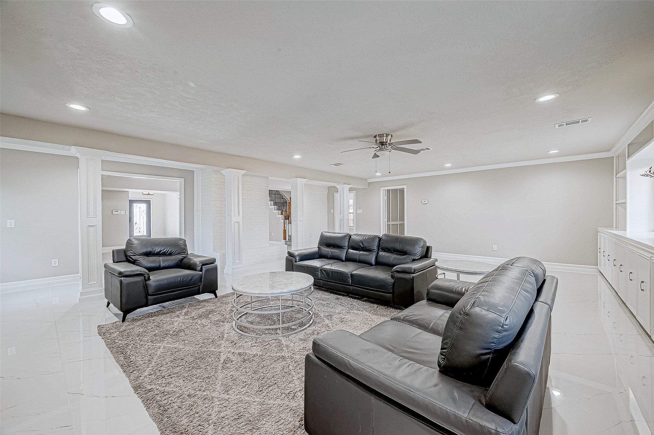 The living room features modern finishes with white tile flooring and recessed lighting.