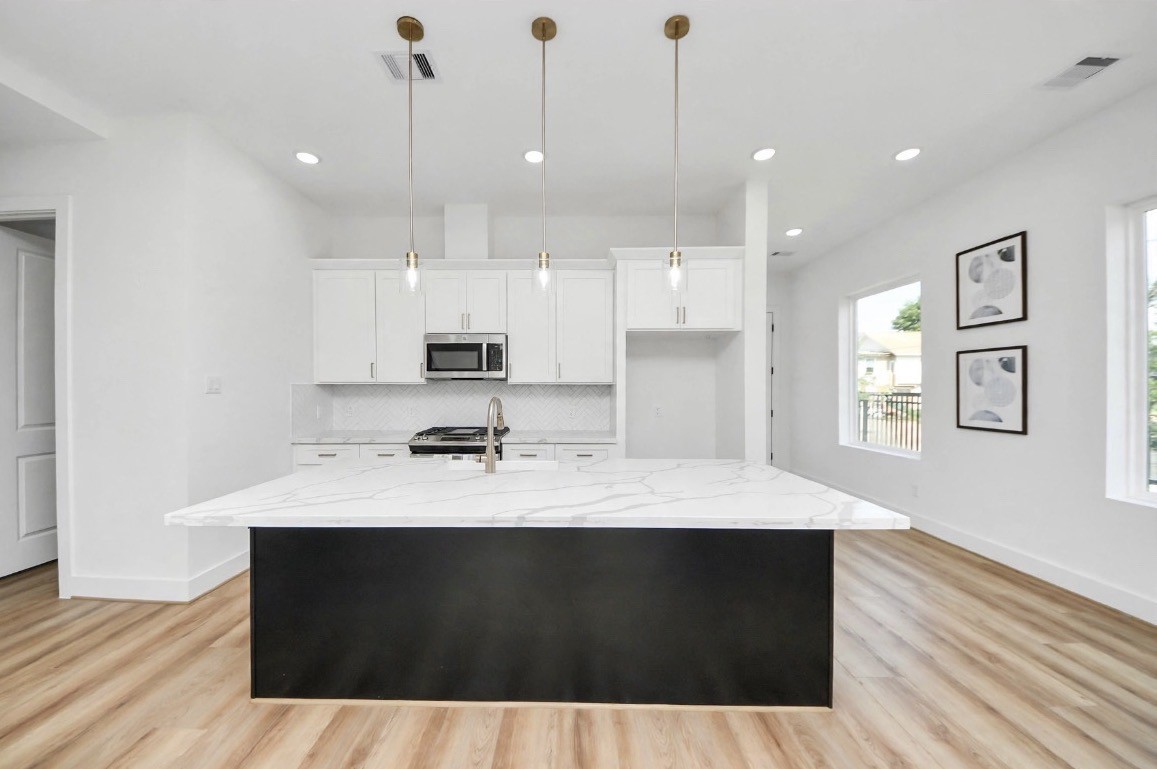 Spacious kitchen featuring a large island, perfect for meal prep, entertaining, and everyday living. Refrigerator is included with the home. Photos are from a separate model home, so furniture and decor may vary. Spacious kitchen featuring a large island, perfect for meal prep, entertaining, and everyday living. Refrigerator is included with the home. Photos are from a separate model home, so furniture and decor may vary.
