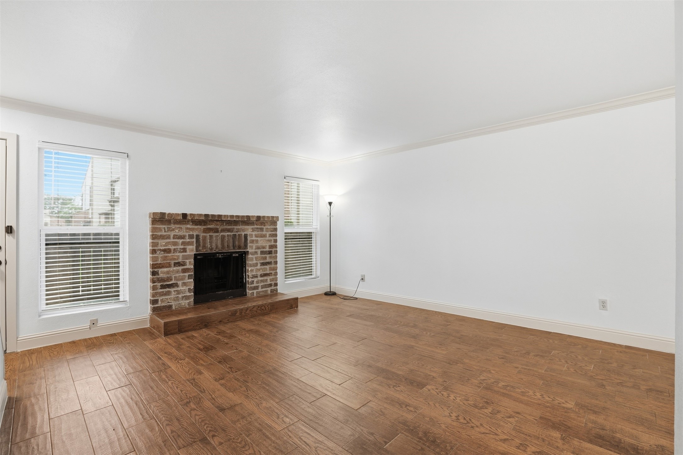 Spacious living area featuring beautiful flooring and a cozy fireplace