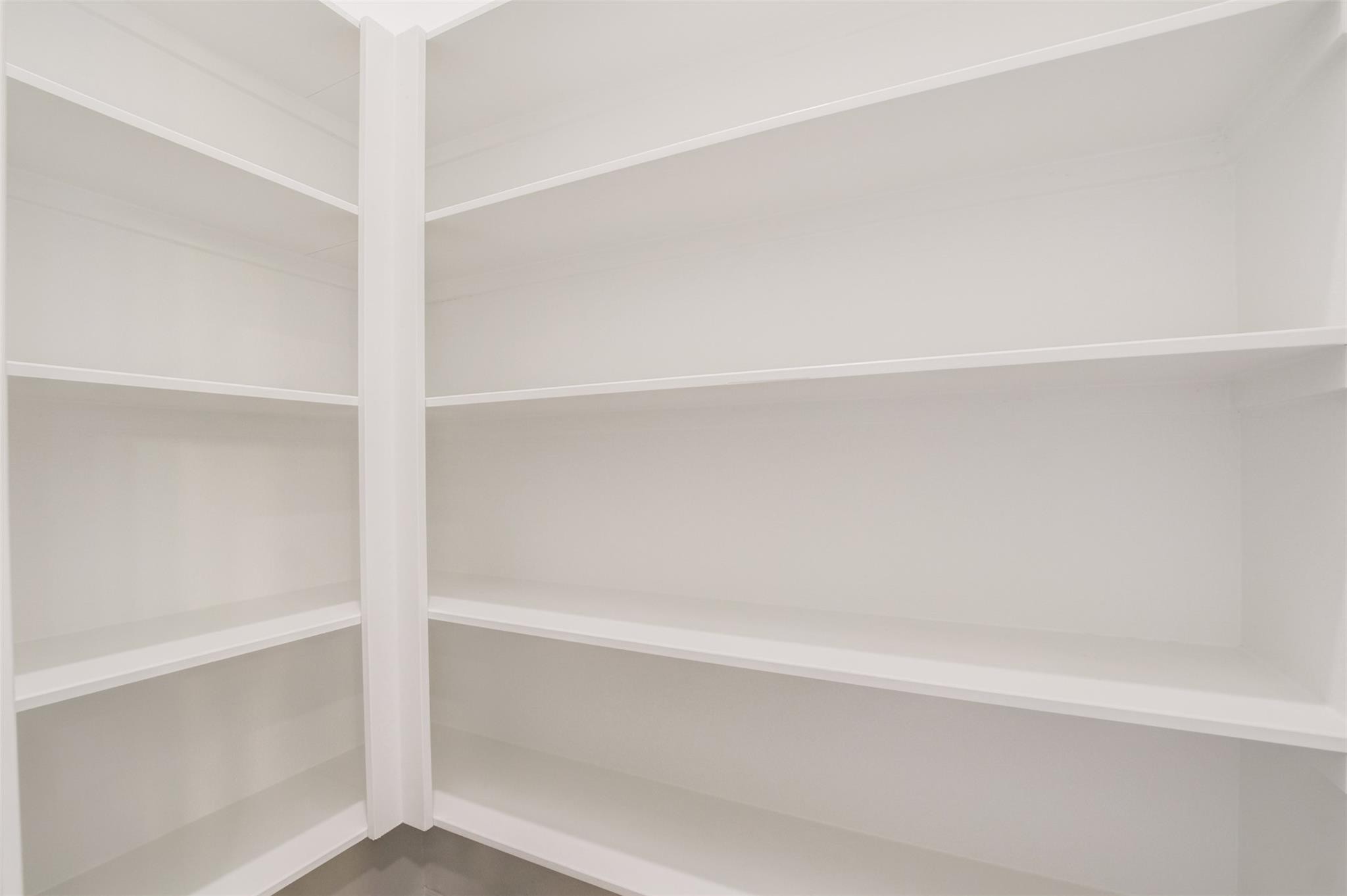 Walk in pantry with ample shelving for storage. Perfect for organizing groceries and kitchen essentials.