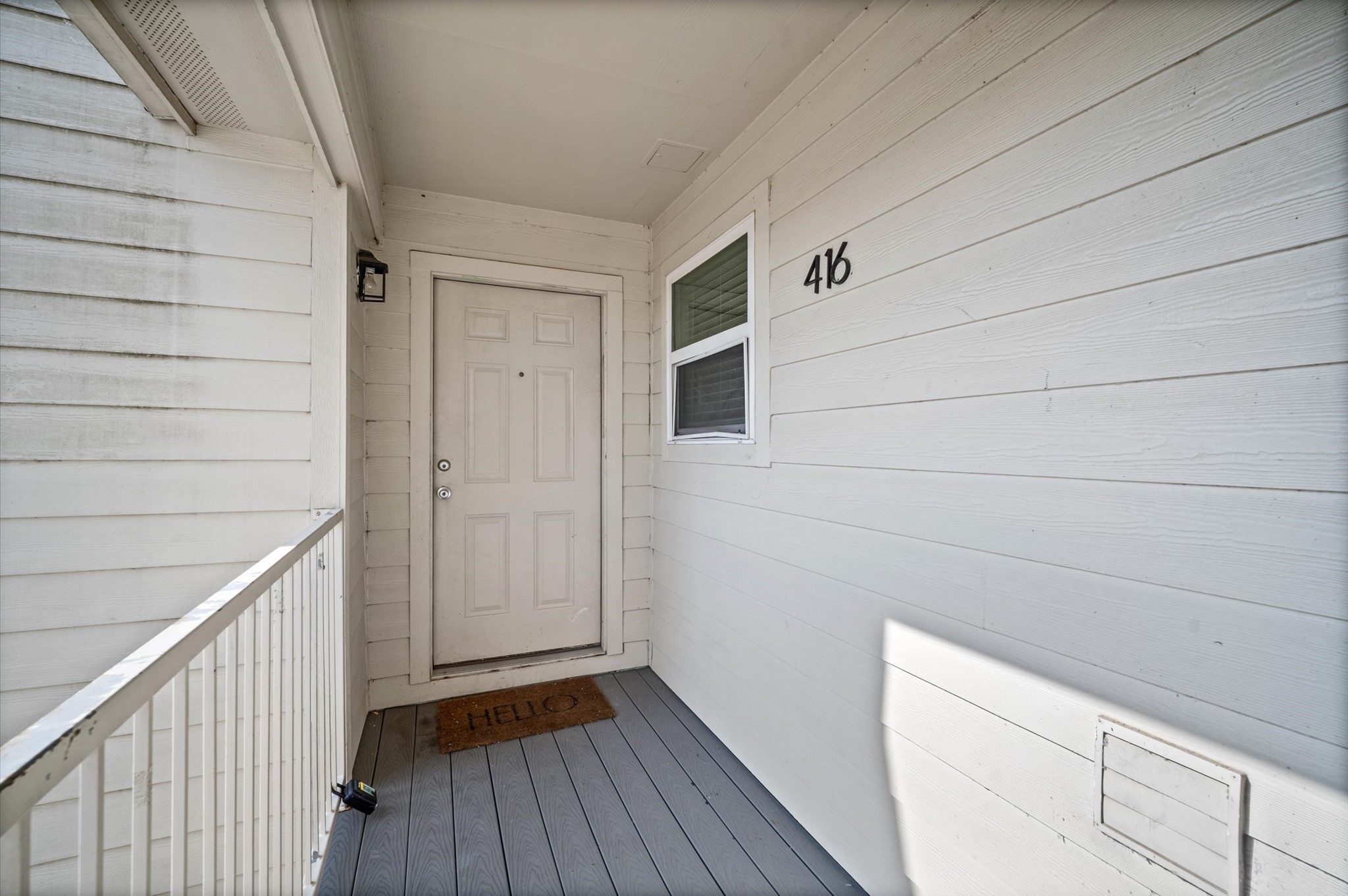 Charming front entry with a welcoming door and cozy porch area, perfect for greeting guests.