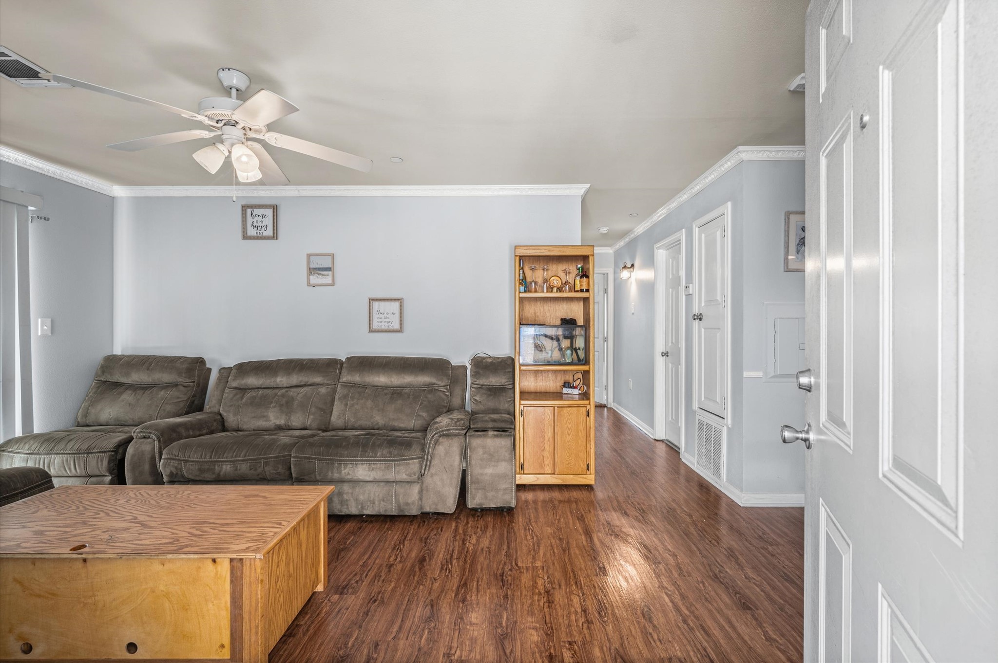 Inviting living room featuring a elegant wood flooring, and a ceiling fan for added comfort.