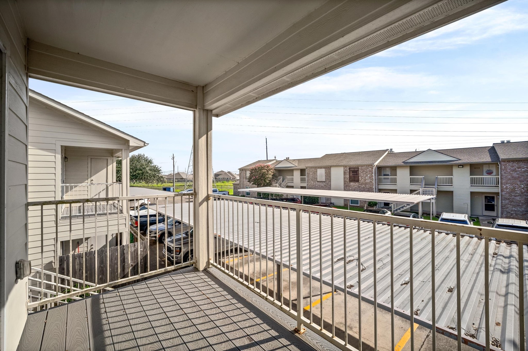 Spacious covered balcony offering a view of the surrounding residential area, perfect for relaxation and enjoying the outdoors.