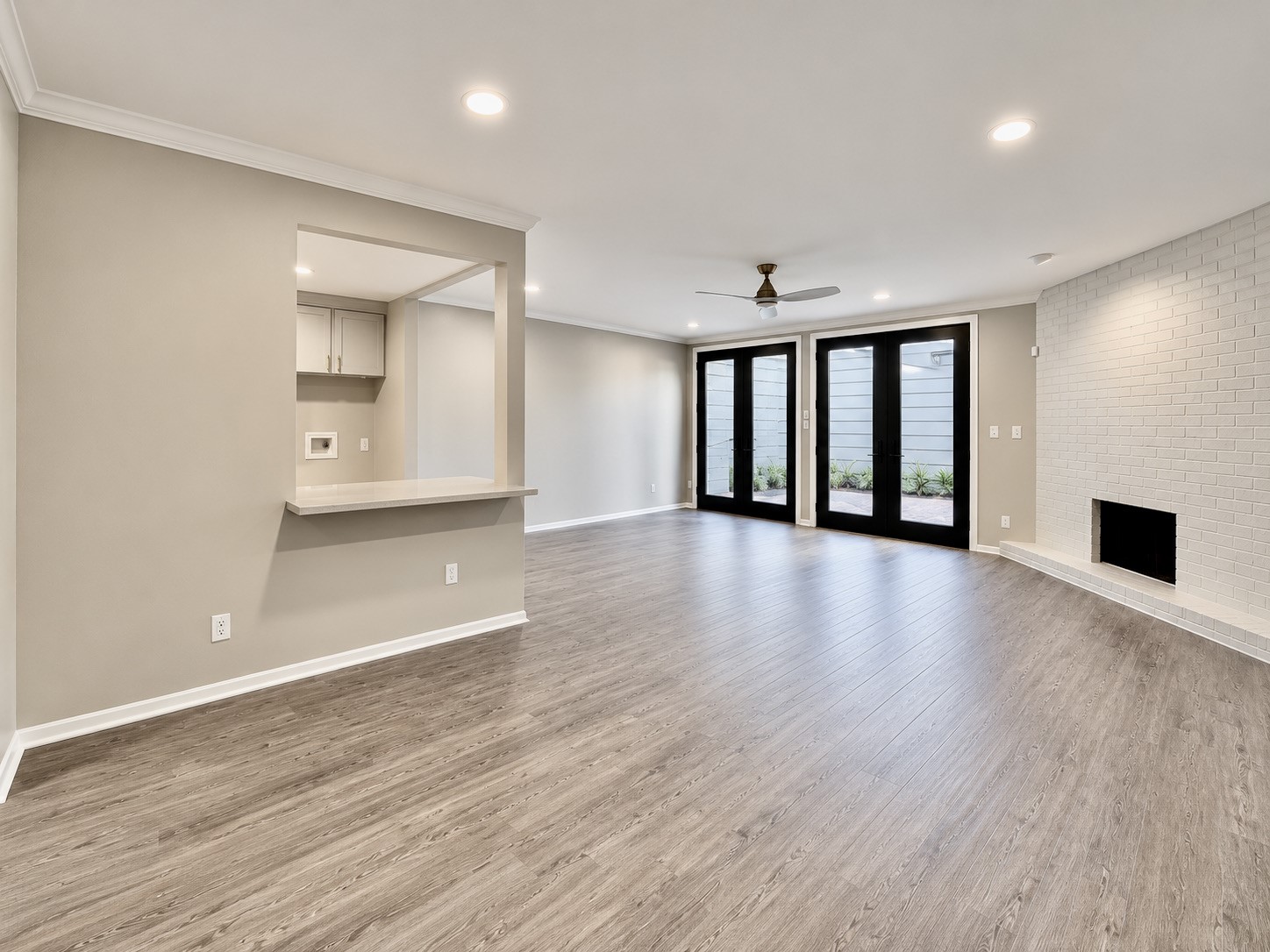 Double french doors lead to a private courtyard and a stately wood burning fireplace anchor the living room