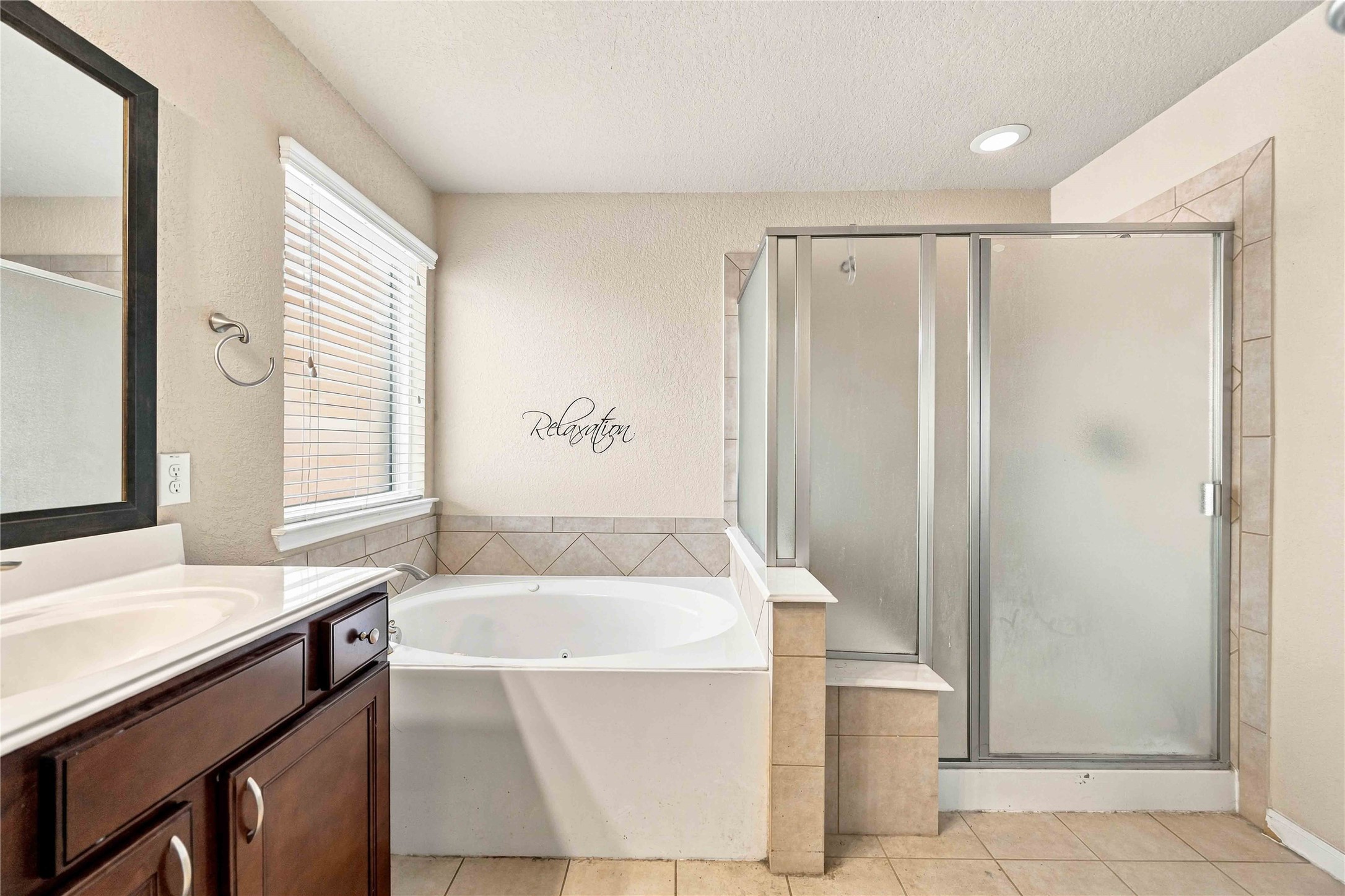 Soaking tub and separate walk-in shower complete the primary bath.