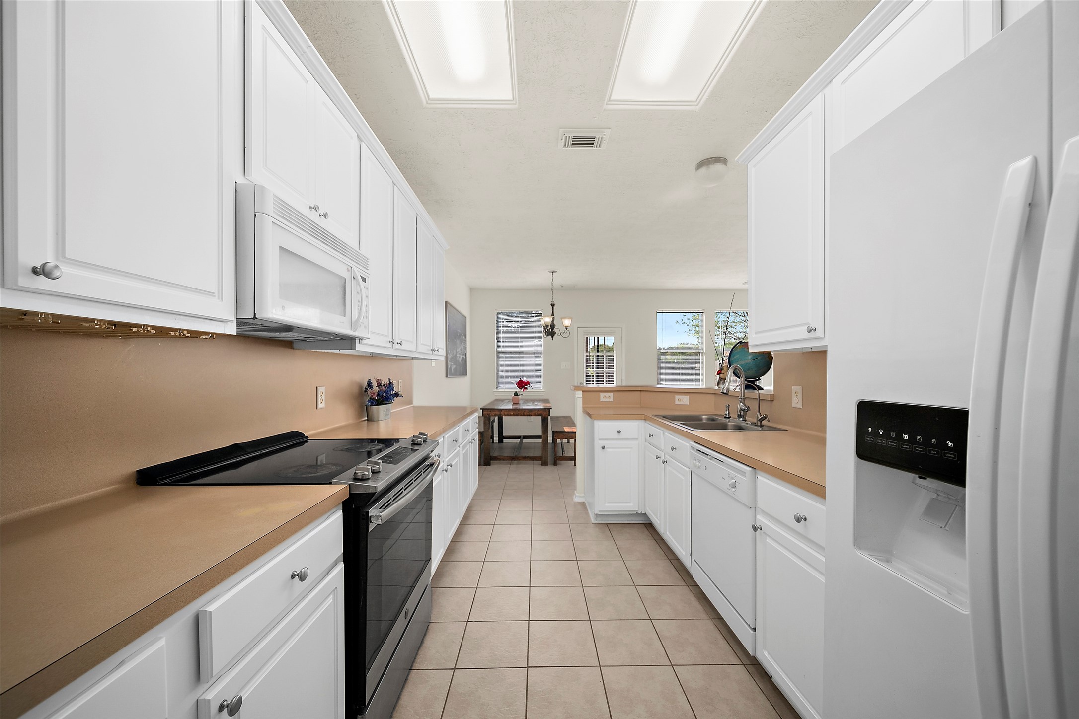 This bright kitchen features ample counter space, sleek appliances, and a seamless flow into the dining area, perfect for entertaining.