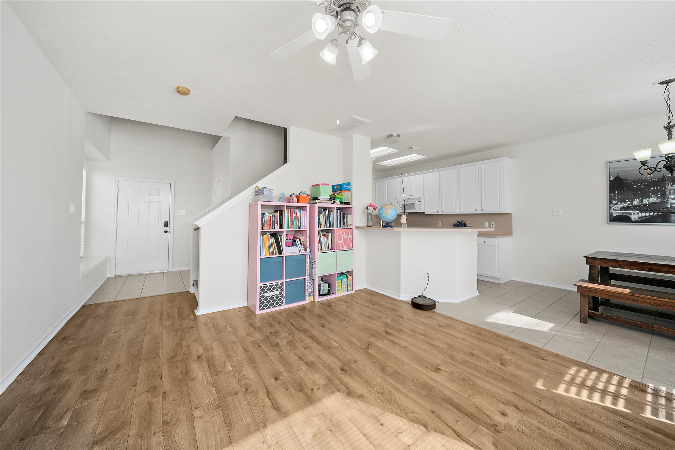This is a two-story home with a beige exterior and a two-car garage. It features a small front yard with a walkway and some greenery. The house appears well-maintained and is part of a closely situated neighborhood.