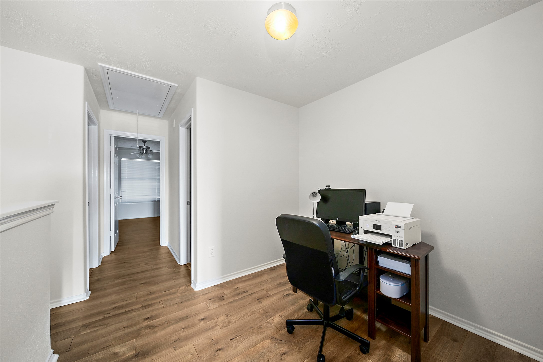 A functional office space with modern laminate flooring, perfect for productivity and focus.