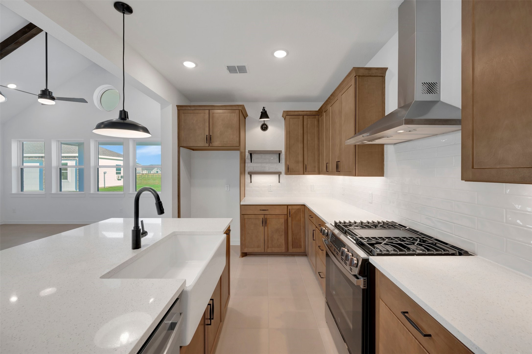Lovely kitchen with light stain cabinets and quartz counters