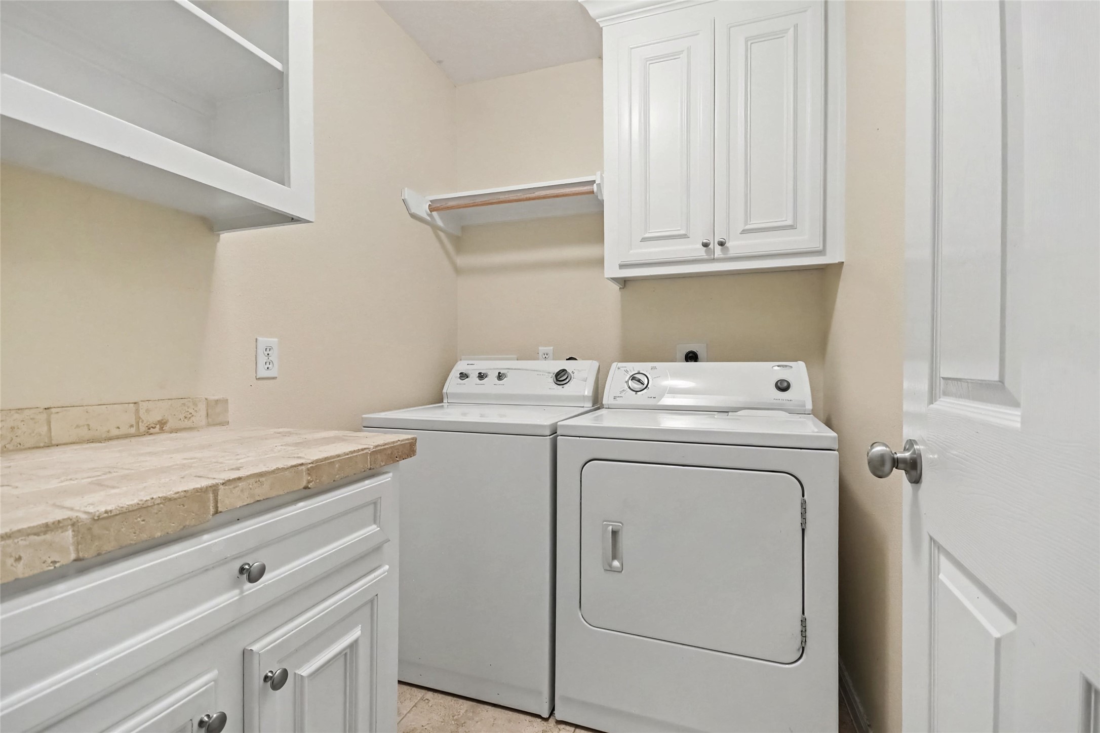 Inside laundry room has ample cabinetry and extra folding space