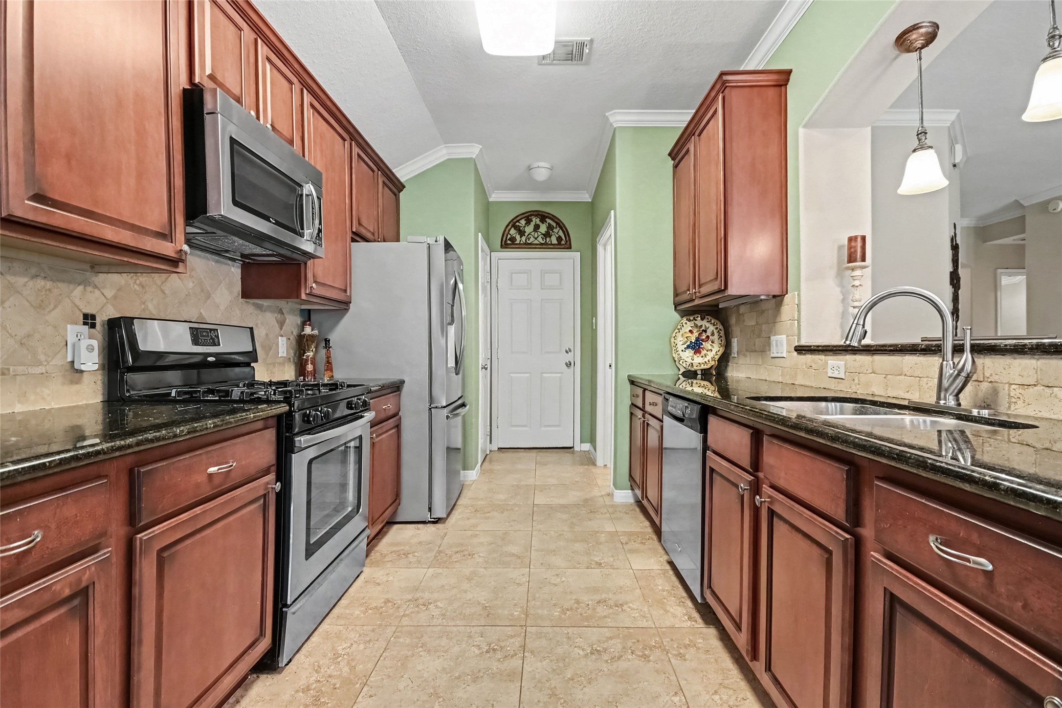 Spacious galley kitchen, featuring Gas cooking, granite countertops and custom cabinetry, oversized porcelain tile Spacious galley kitchen, featuring Gas cooking, granite countertops and custom cabinetry, oversized porcelain tile