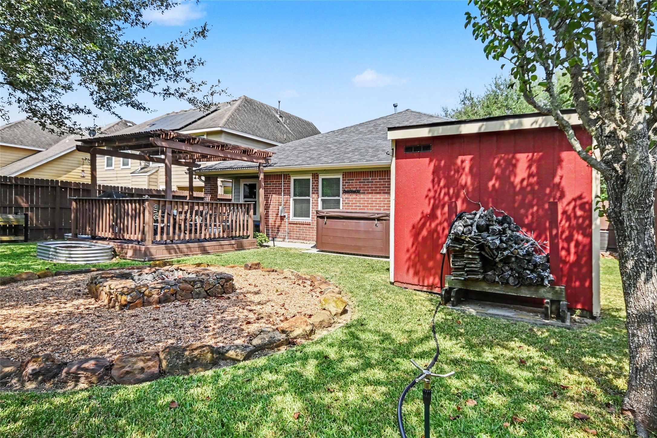 Another view from the corner of the backyard where you can see storage for the firepit wood