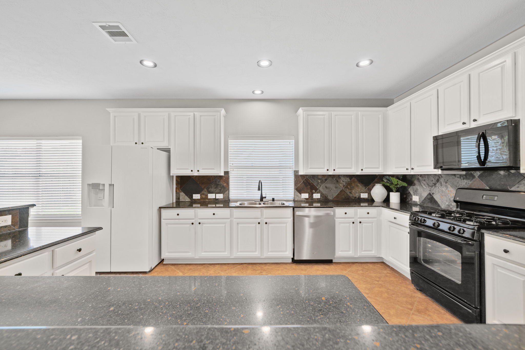 Functional kitchen featuring granite counters and modern appliances.