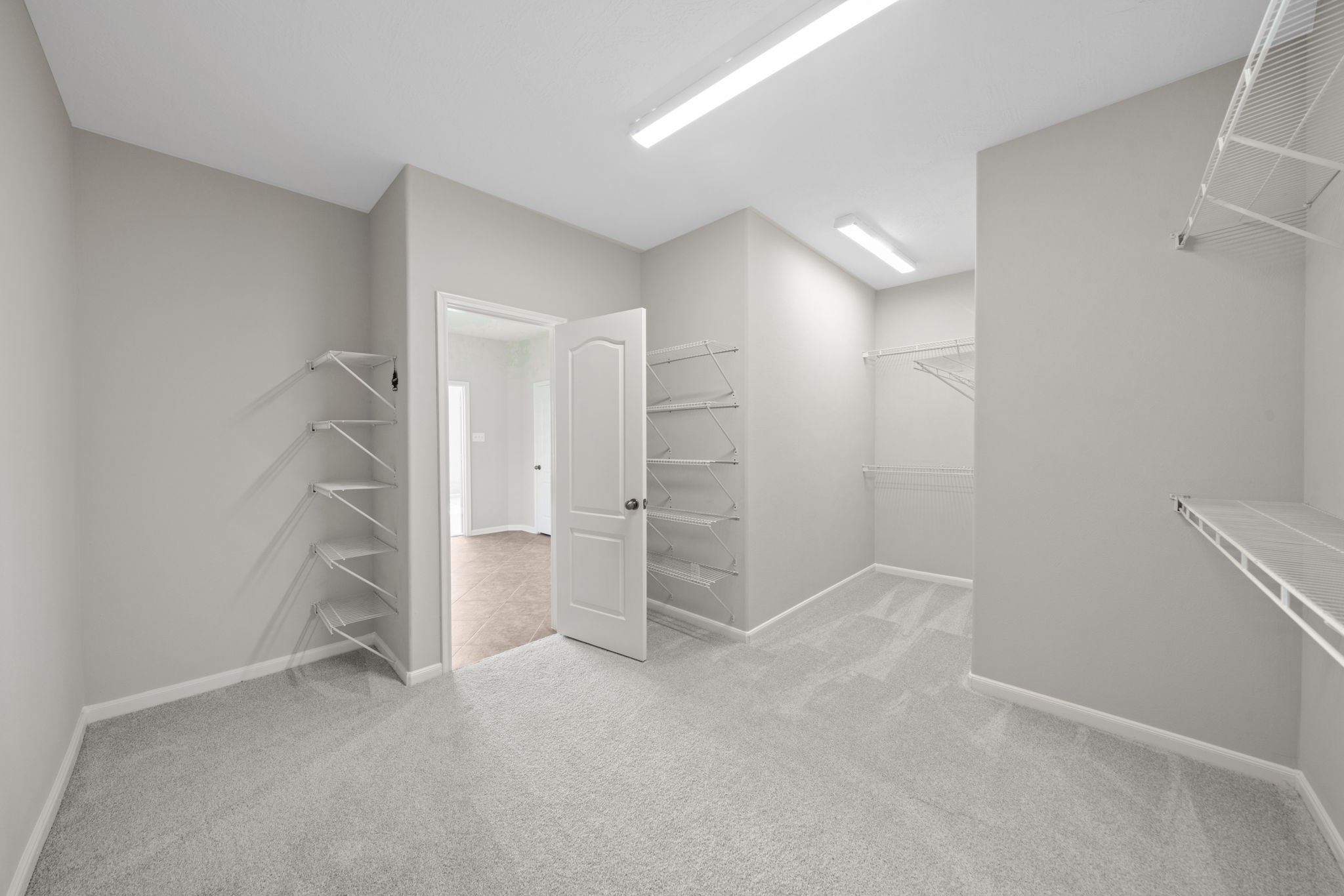 Oversized primary closet with abundant storage space.media, playroom, or office space.