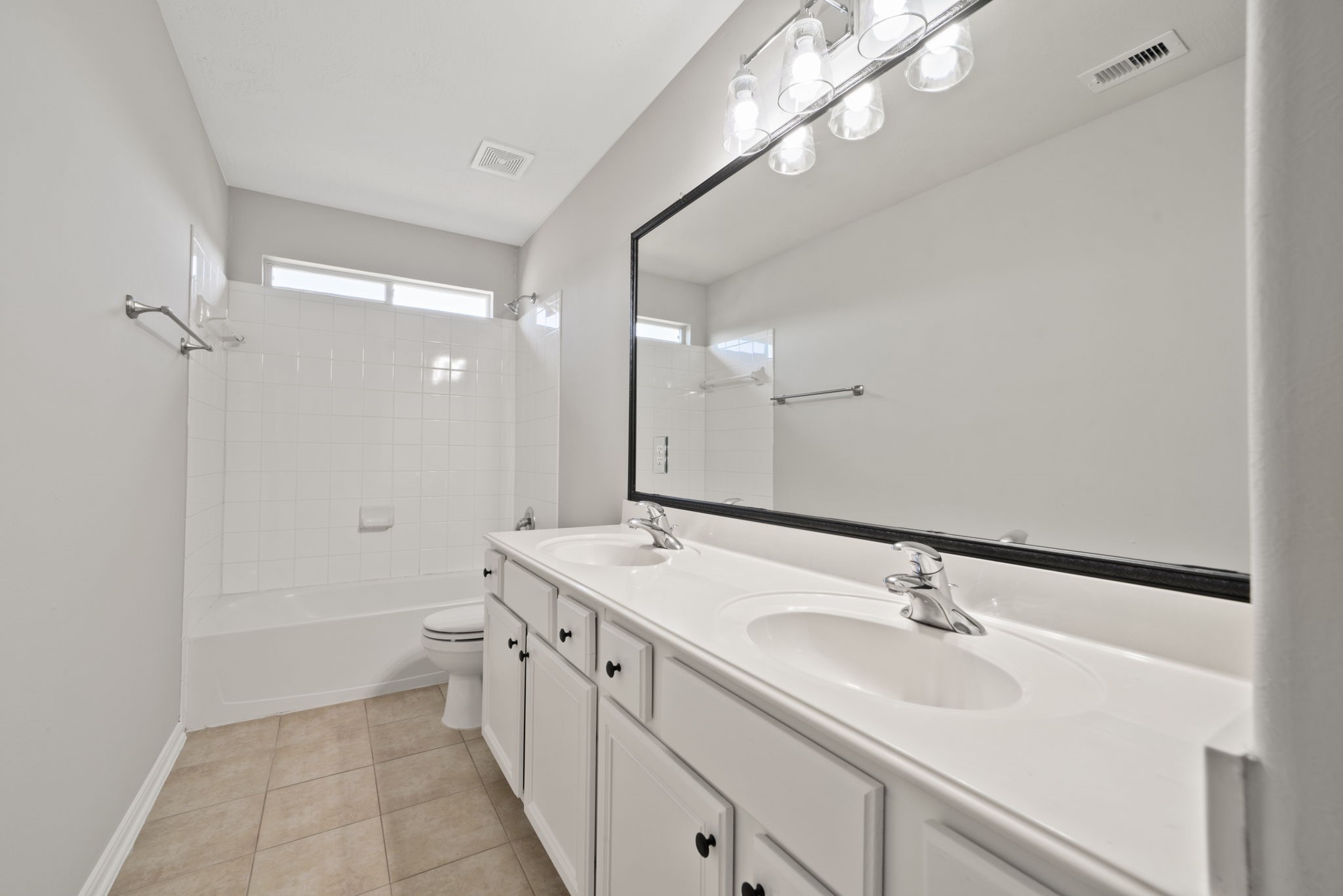 Secondary bathroom with double sinks.