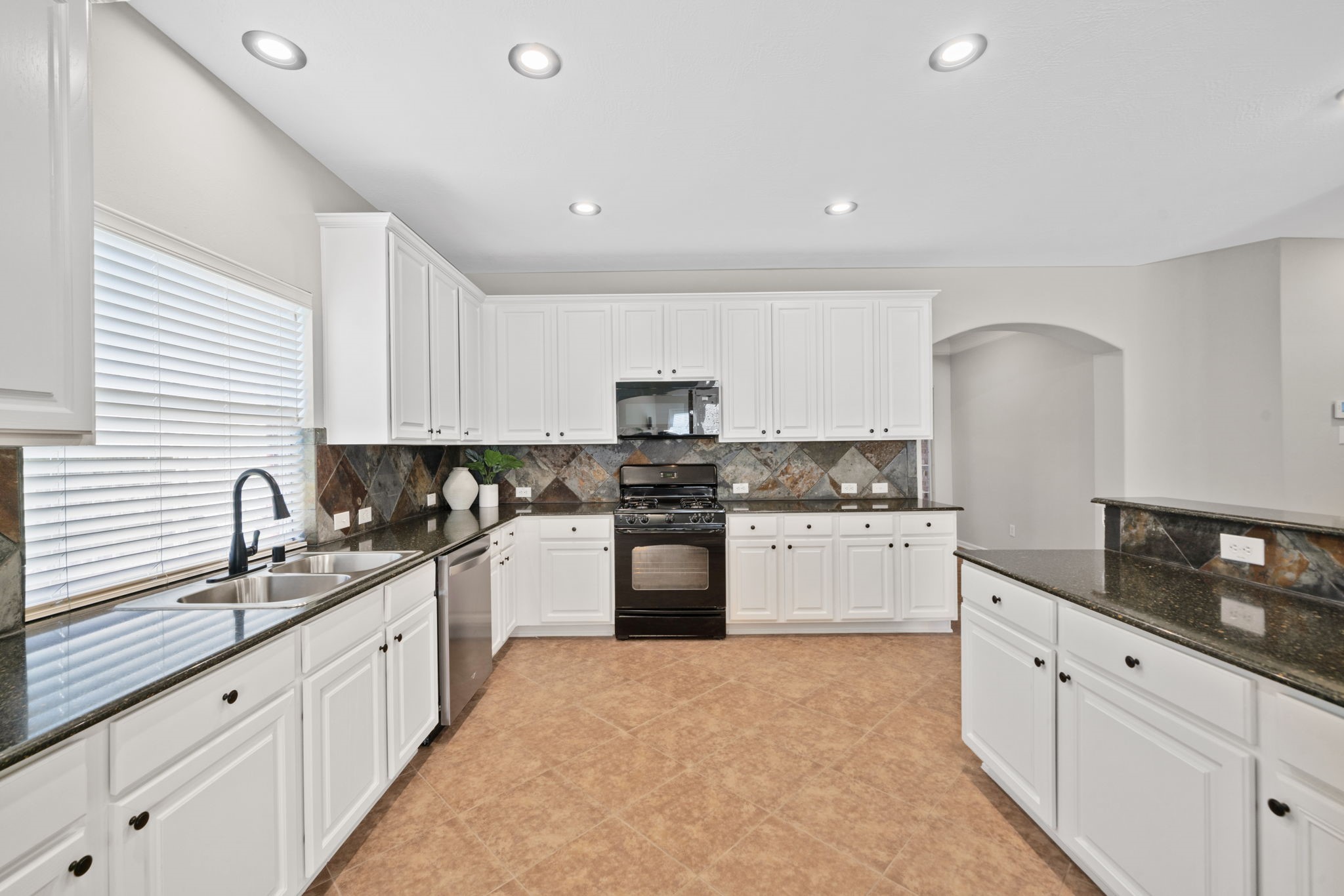 Spacious kitchen with granite countertops and abundant cabinet space.