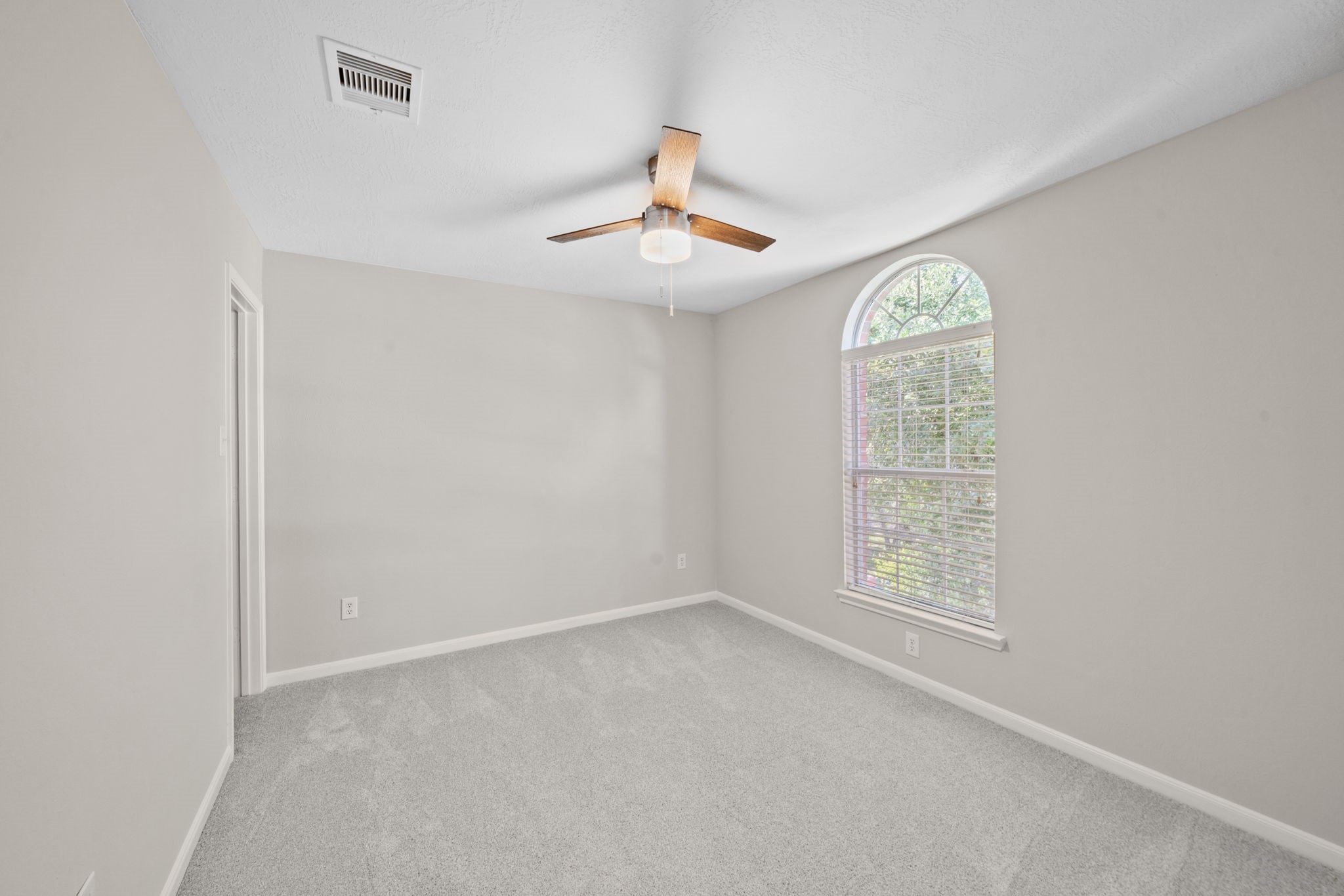 Spacious upstairs bedroom with neutral finishes.