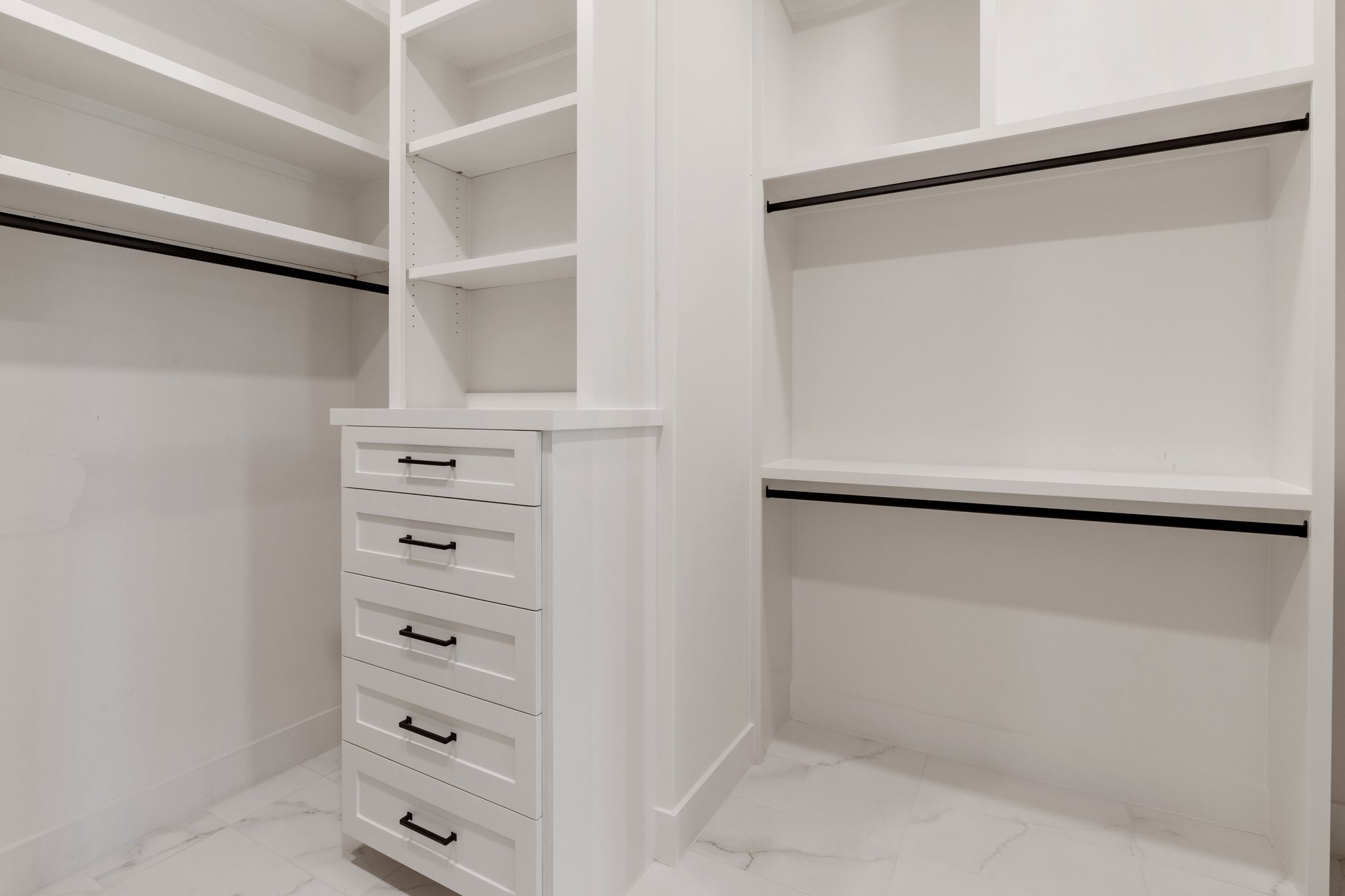 A peek into the large walk-in closet with "his and hers" dressers and hidden storage.