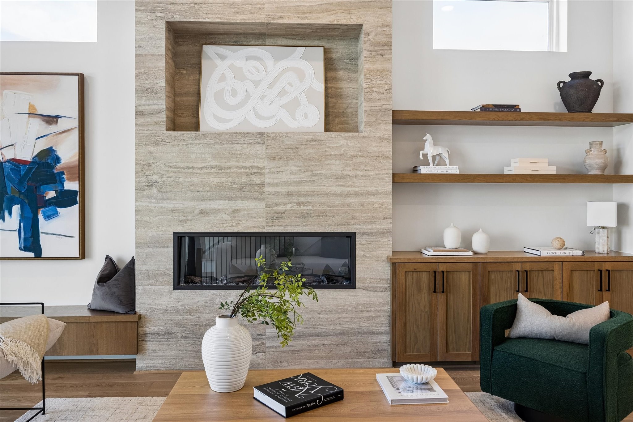 A closer up view of this stunning floor-to-ceiling travertine mantle surrounding a fireplace with color-changing electric insert.