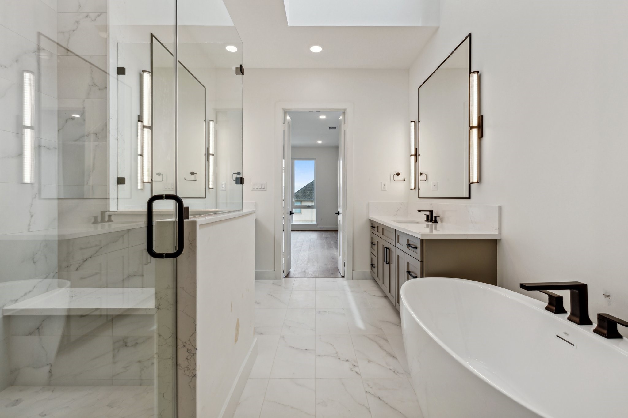 Another view of this to-die-for primary bath. Enjoy the 5-foot freestanding soaking tub, spacious walk-in shower with shampoo niches and built-in bench.