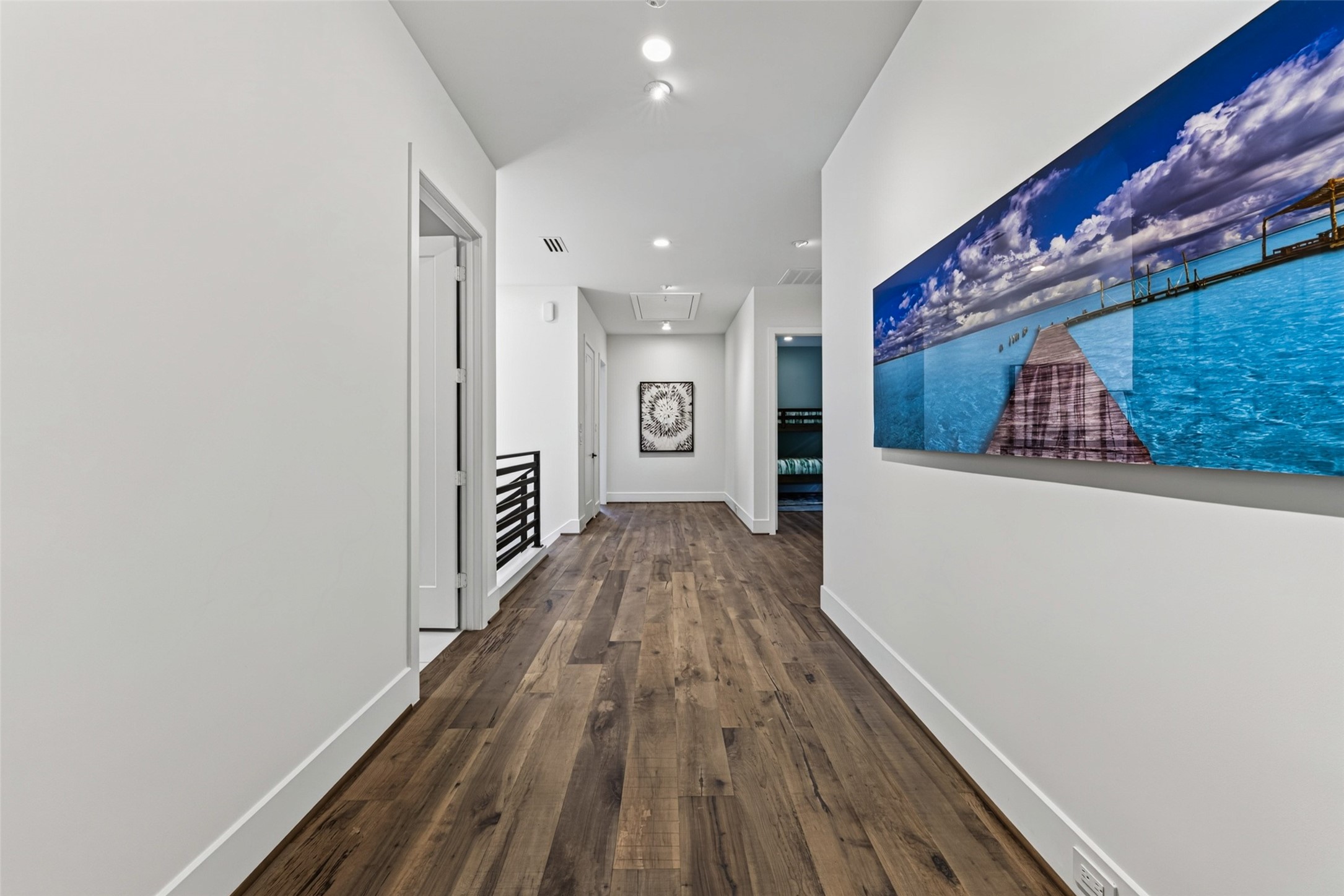 The secondary bedrooms are located down the hall from the primary. Art lighting has been added to feature your collection.