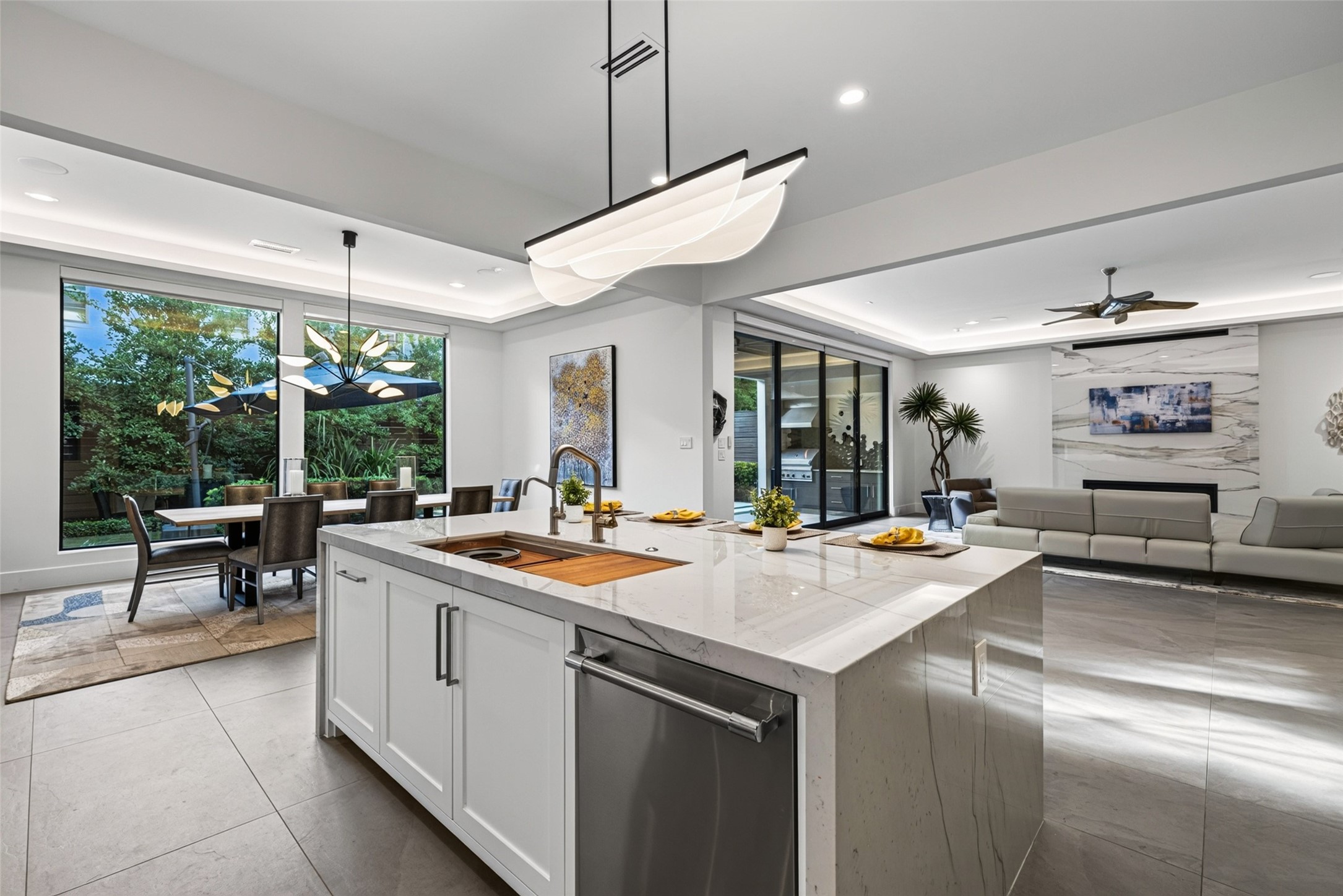 A double waterfall edge quartzite island perfectly compliments the Italian porcelain flooring and floor to cieling slab in the living room.
