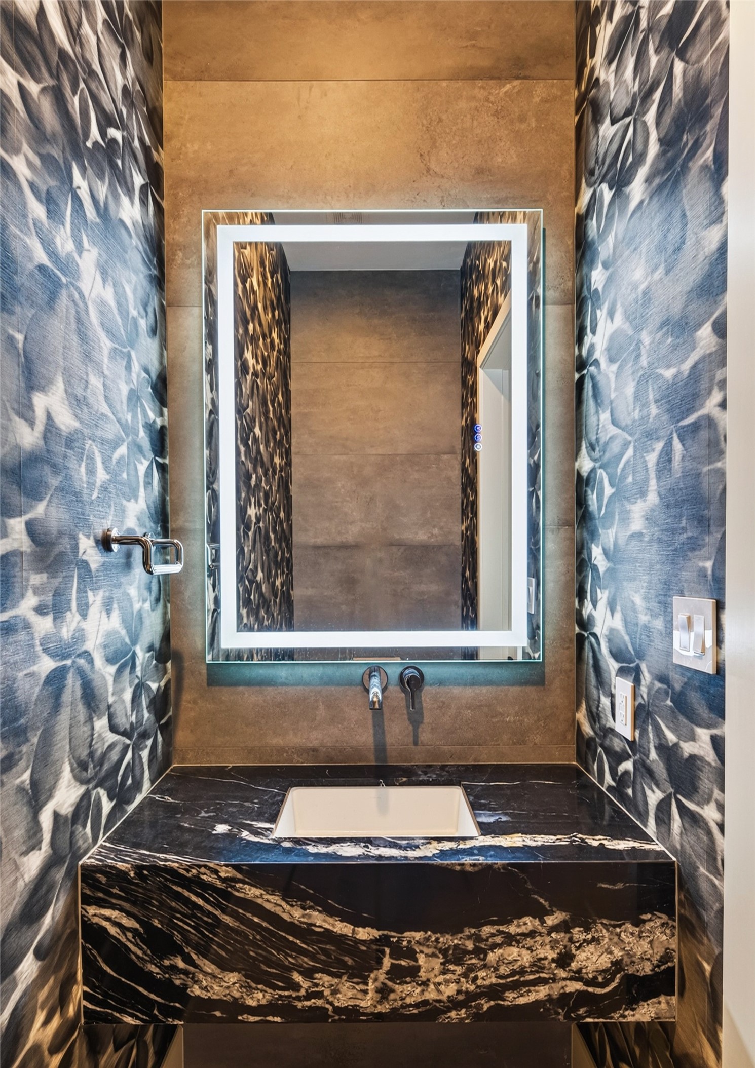Every bathroom in the home features anti-fog lit mirrors adding an additional element of sophistication. This is the powder room on the first floor.