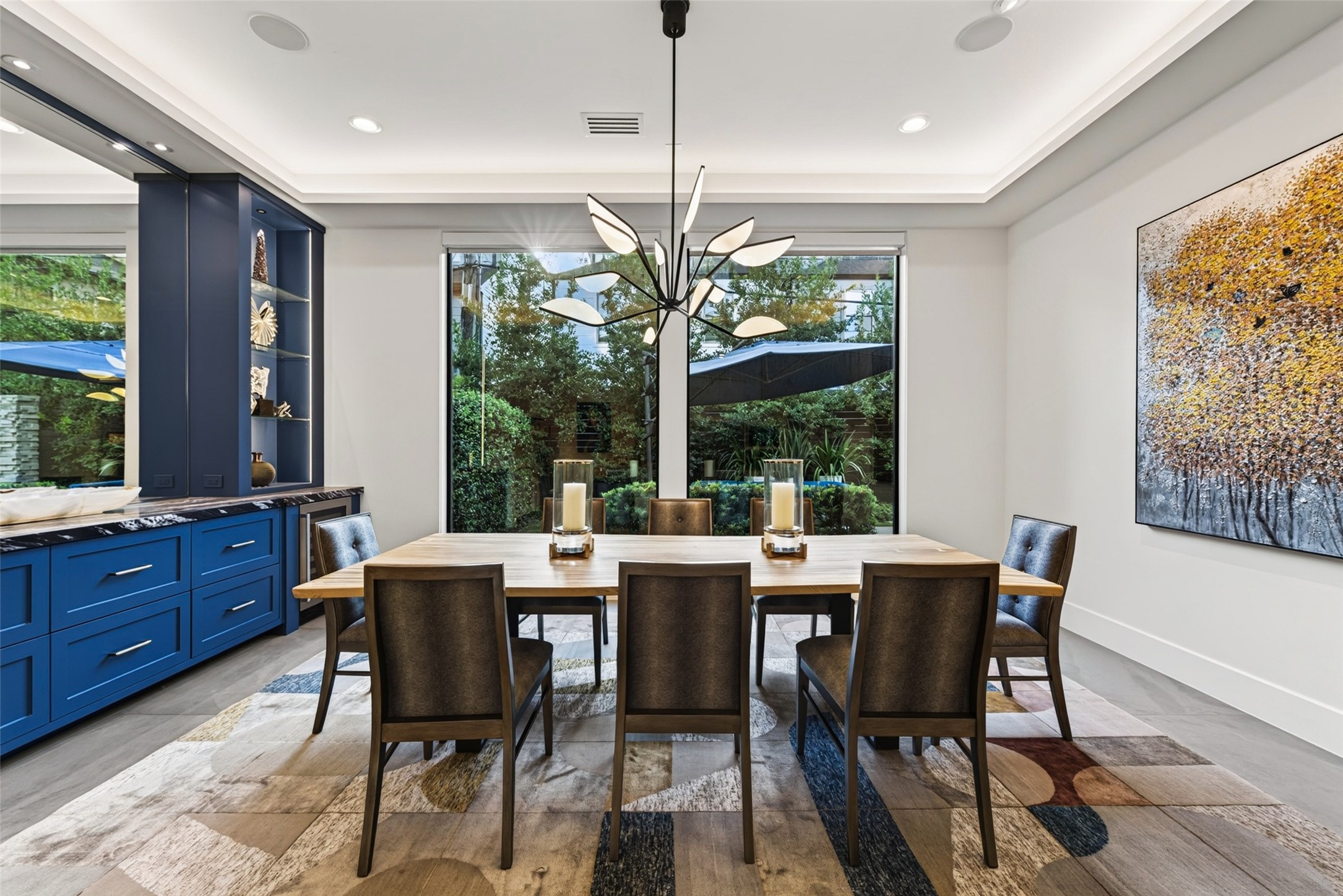 The large dining room has expansive plate glass windows looking over the lushly landscaped back yard.