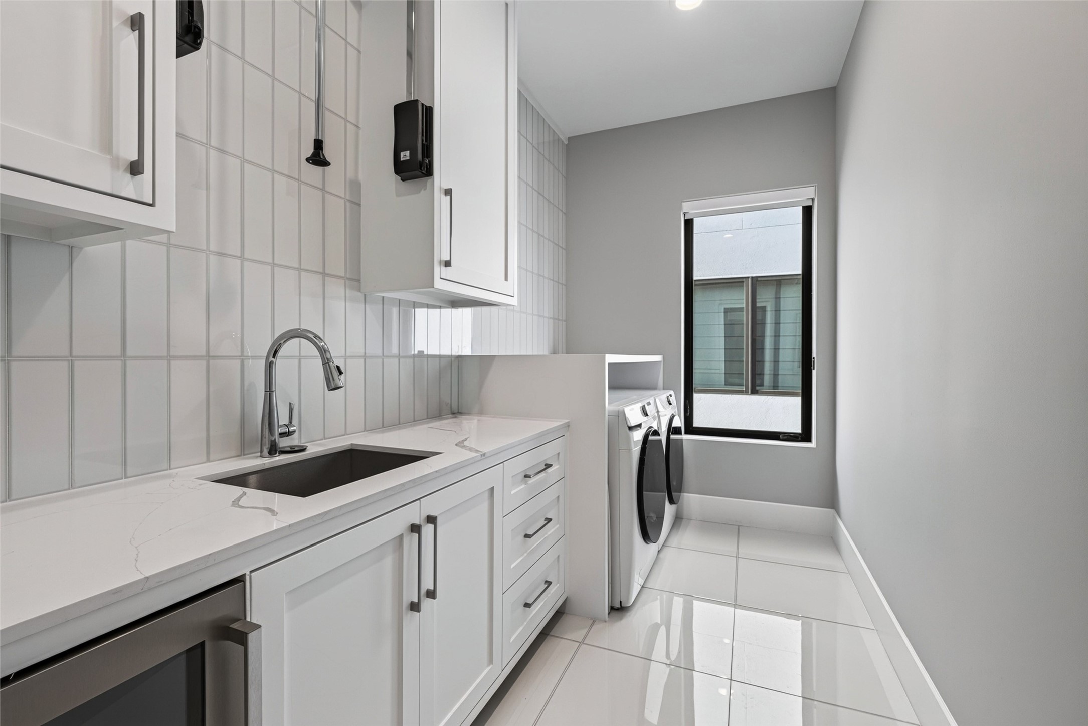 The utility room is conveniently located on the same floor as all of the bedrooms, and includes a beverage refrigerator.