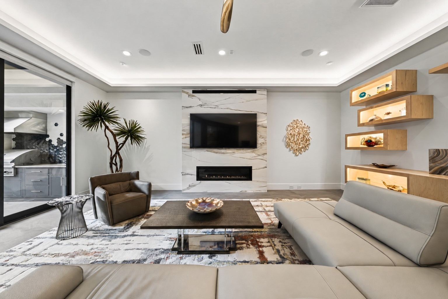 The floor to ceiling porcelain slab frames the gas fireplace for showcasing art or lounging and watching TV.