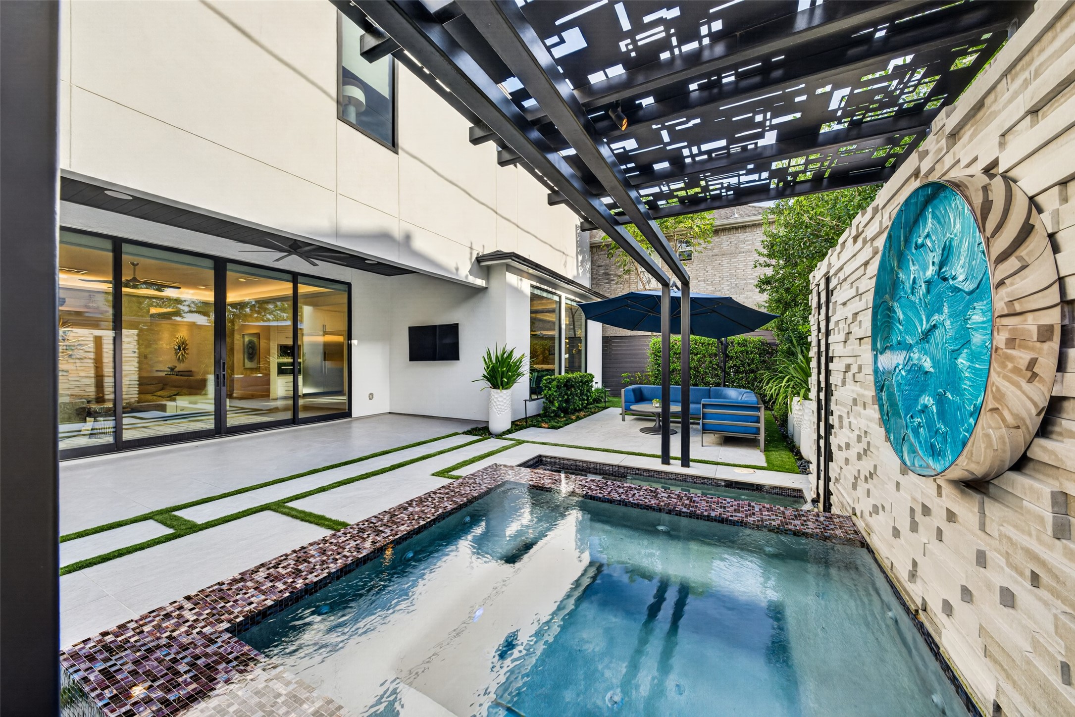 Custom outdoor tile and stonework, an landscape irrigation system and turf inlay make the outdoor space easy to maintain.