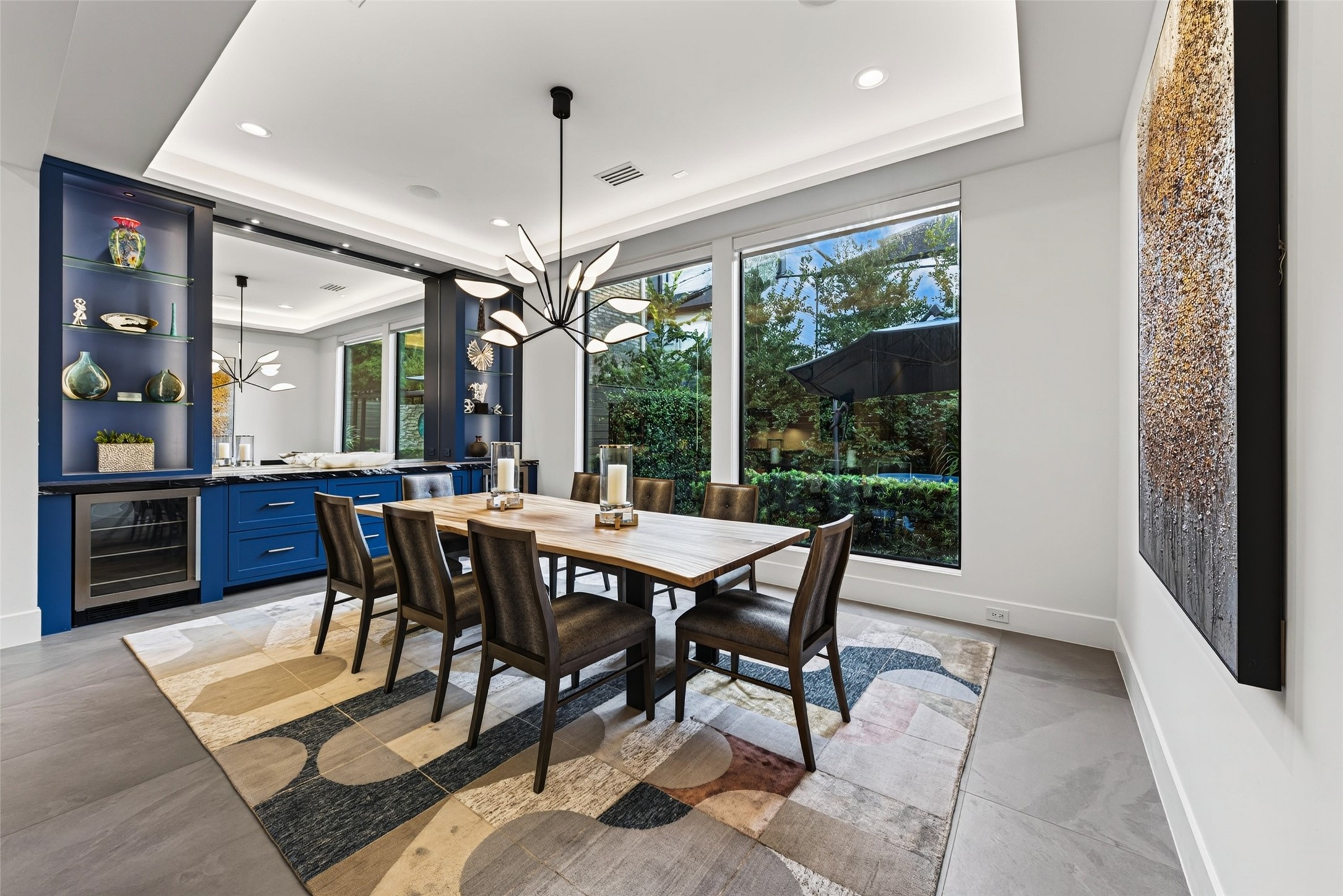 The dining room is adjacent to the kitchen and features lit shelves, a buffet area, and 2 beverage refrigerators.