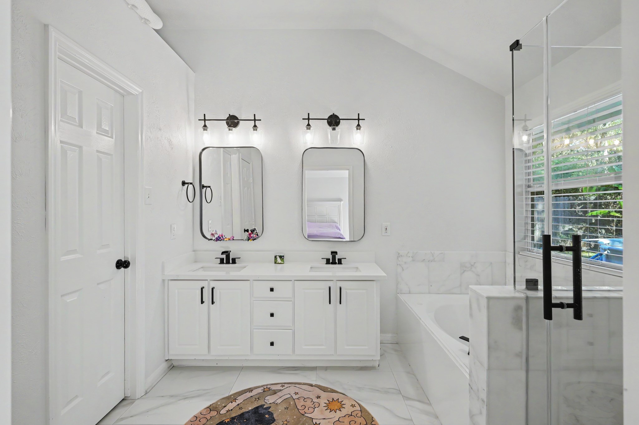 Primary bath with double sinks, matching mirrors, and separate tub and shower